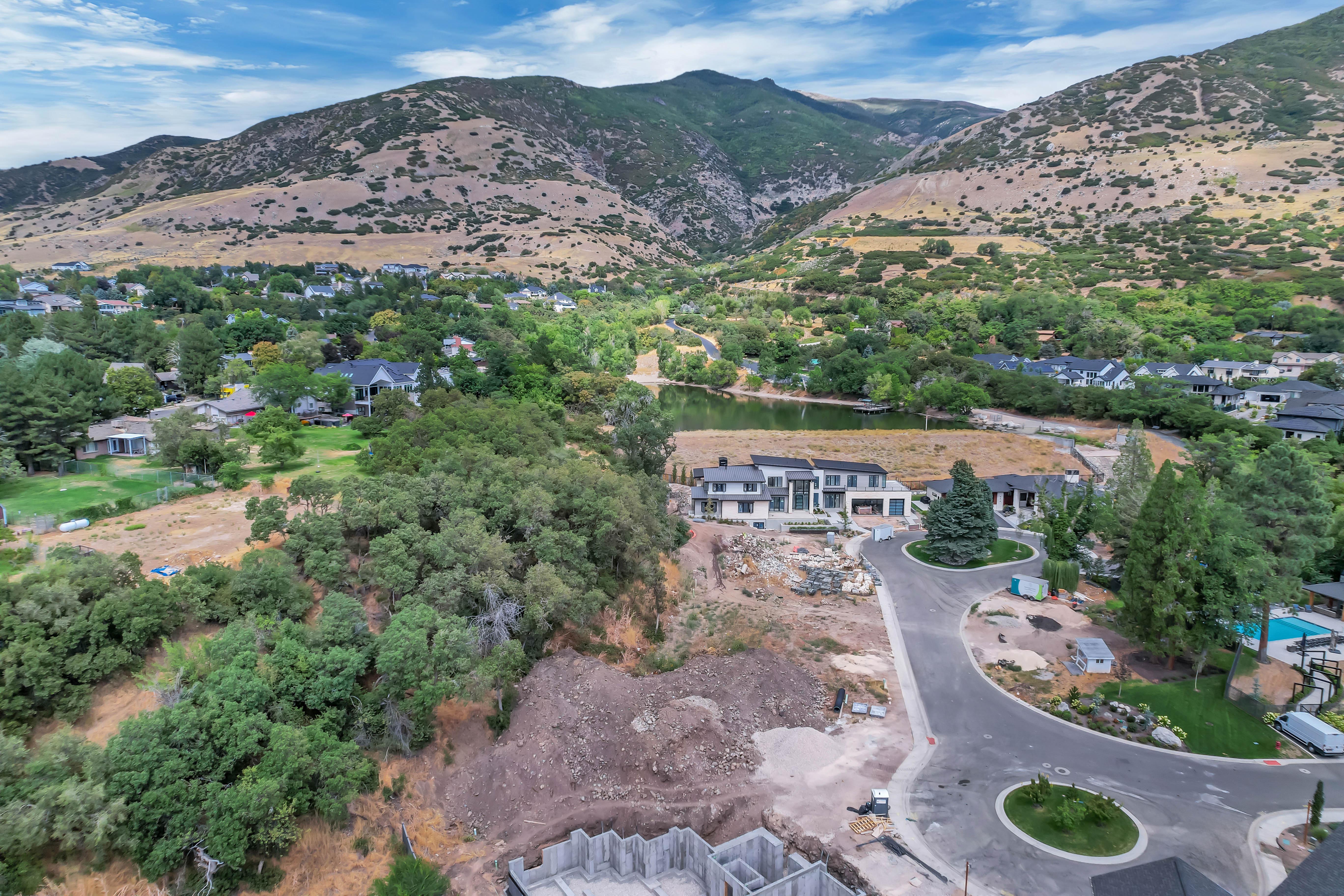 Aerial perspective showcasing a developing residential area with mountainous terrain backdrop