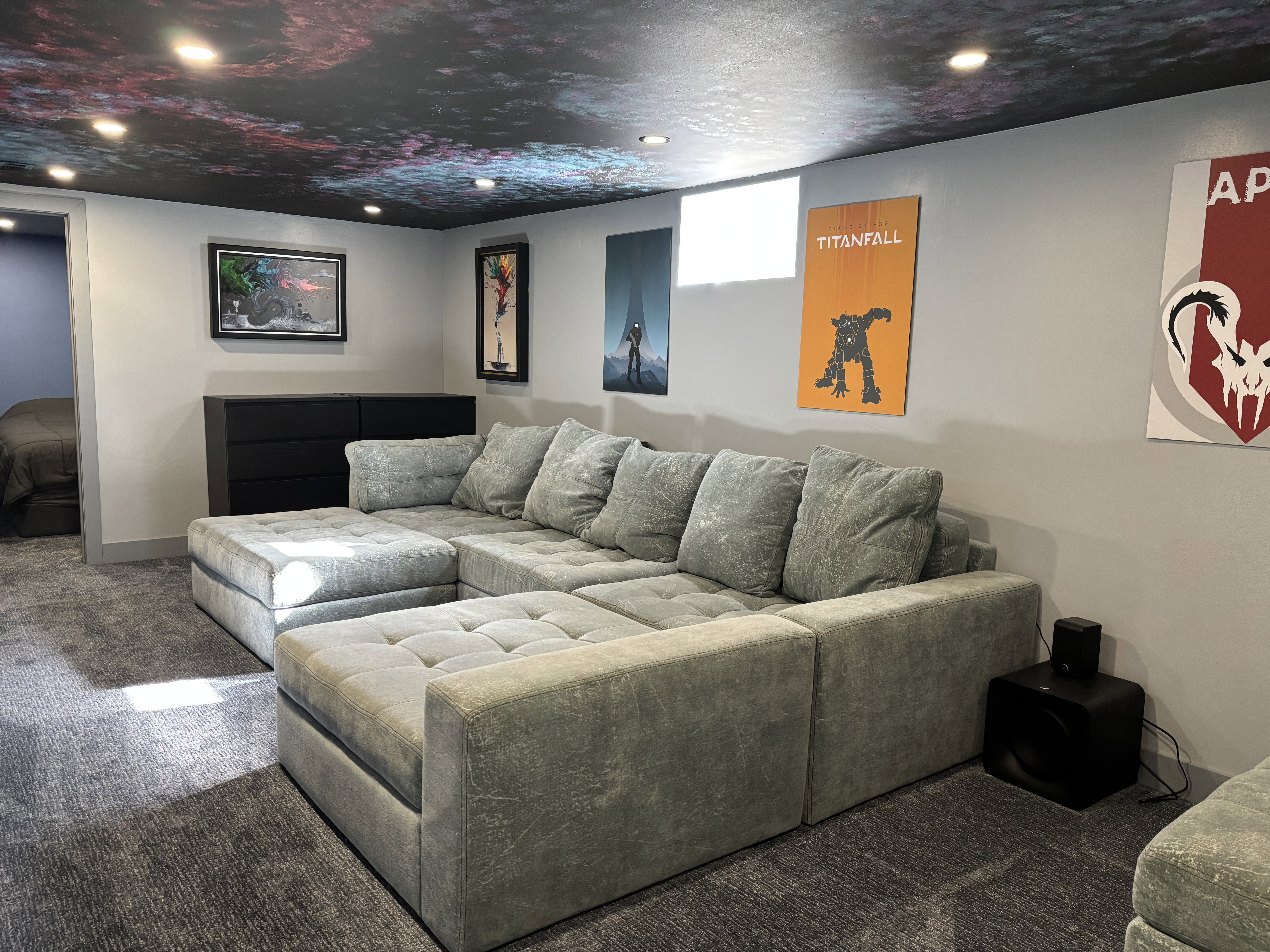 Spacious entertainment area featuring a patterned ceiling, recessed lighting, light gray walls, blue-gray carpeting, and a built-in window