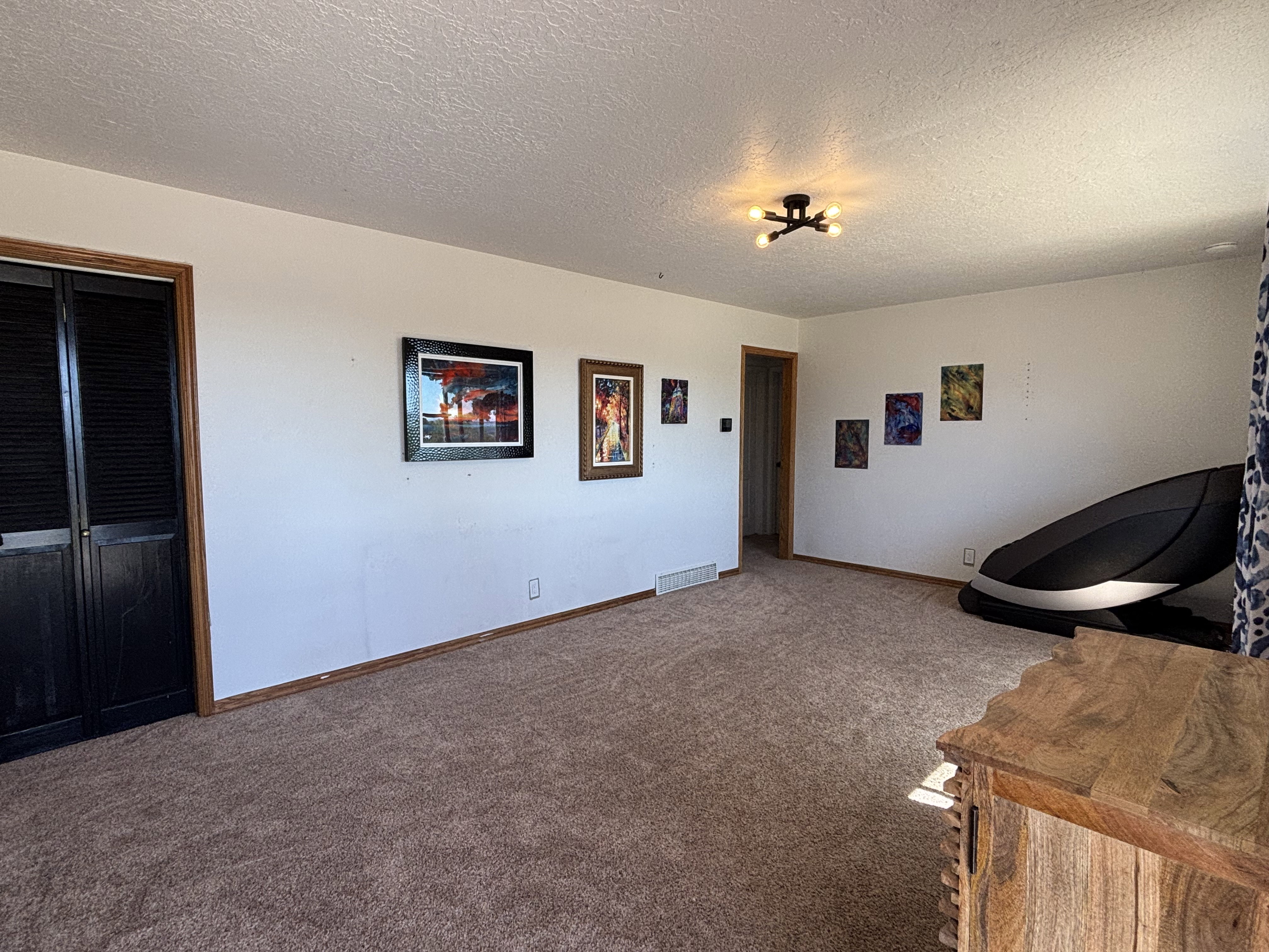 Spacious room featuring neutral carpeting and white walls