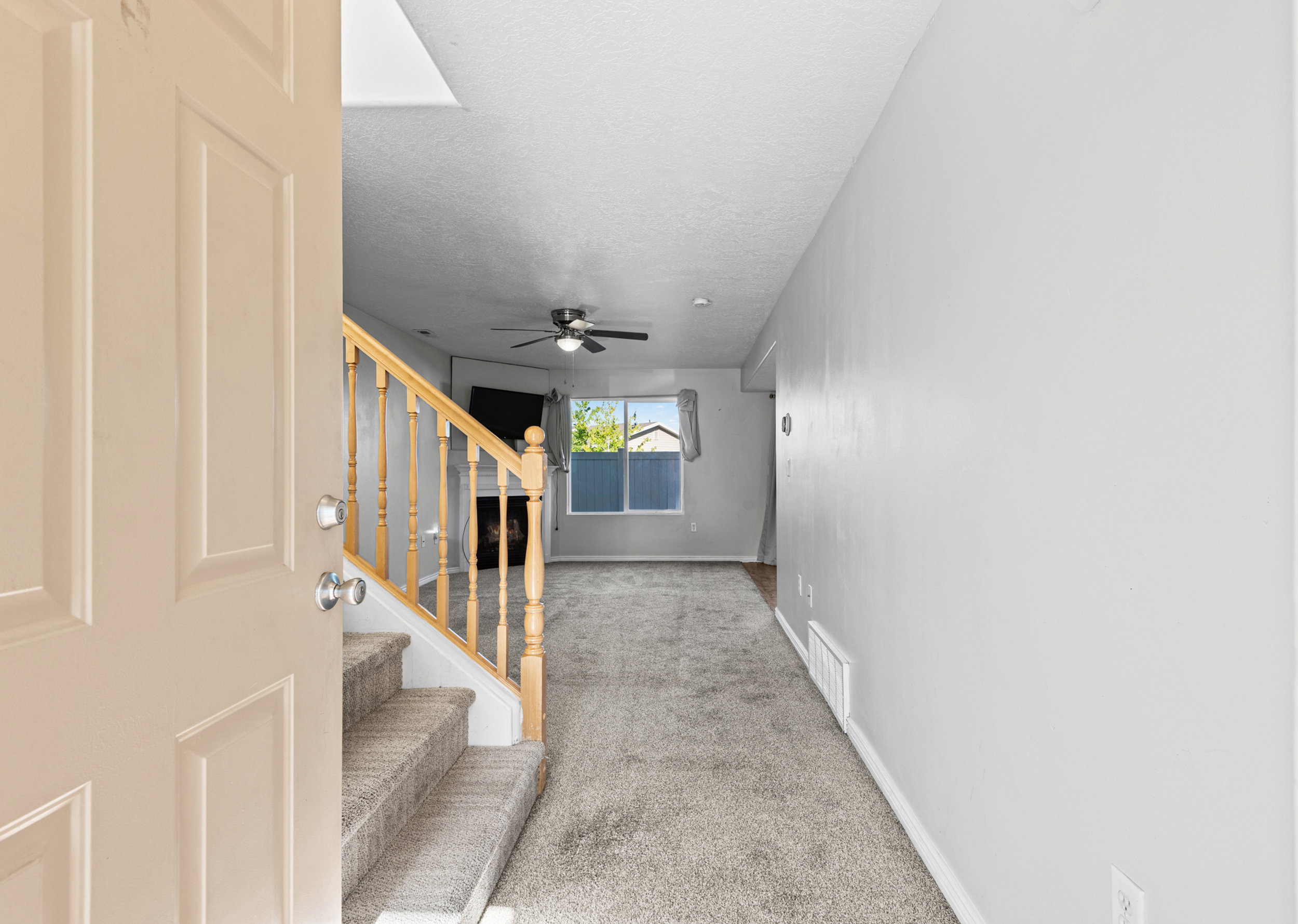 Entryway featuring a staircase with carpeted treads and natural wood banister