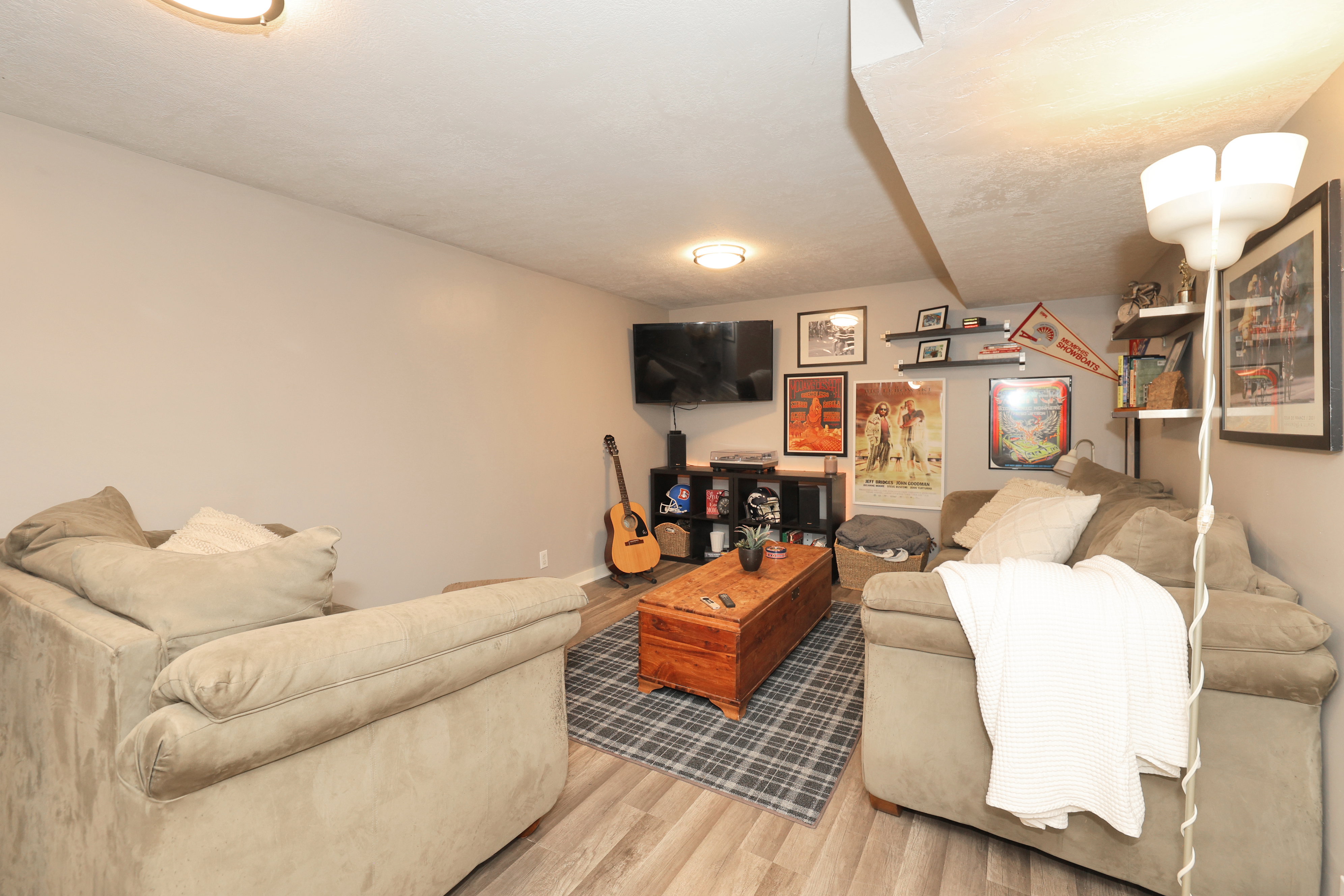 Finished lower-level space featuring light-toned walls and wood-finish flooring