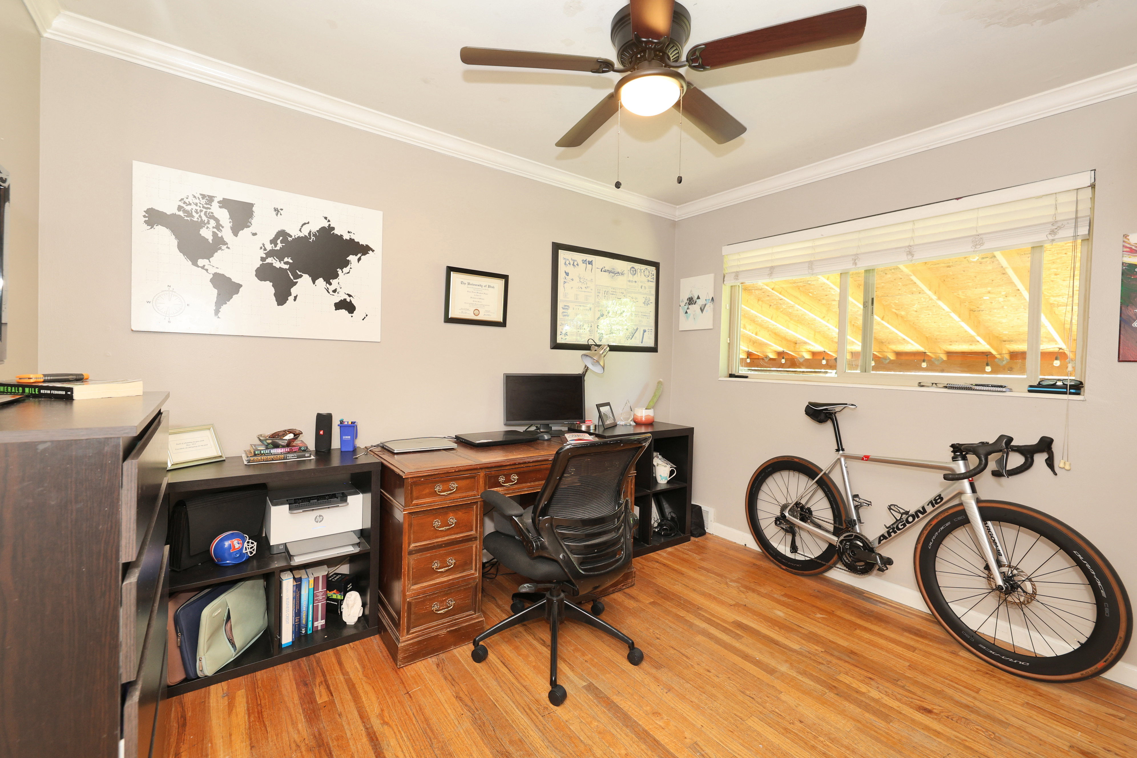 Interior room featuring wood-finish flooring, a ceiling fan with integrated lighting, and crown molding