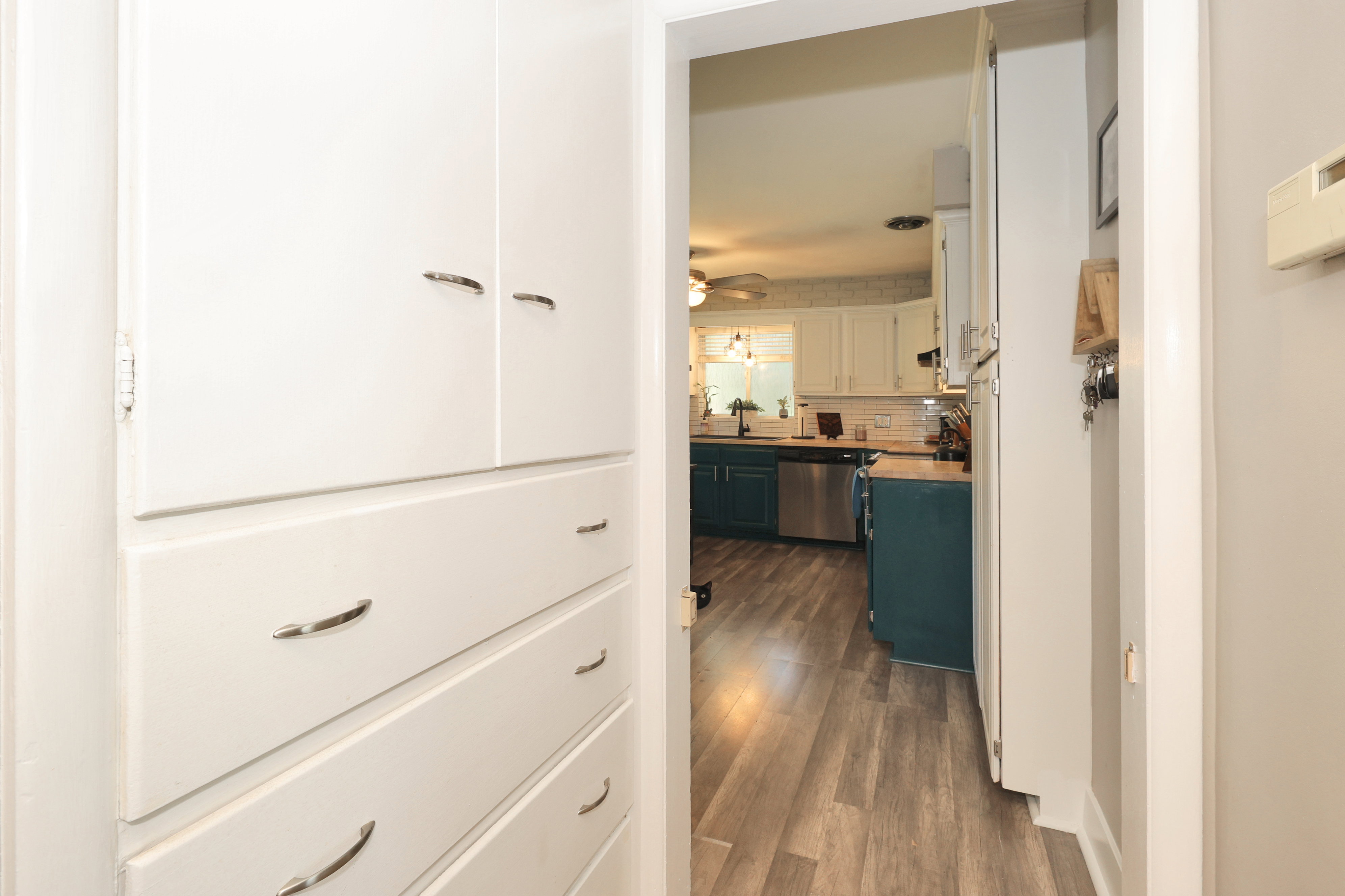 Built-in white storage cabinetry with chrome hardware
