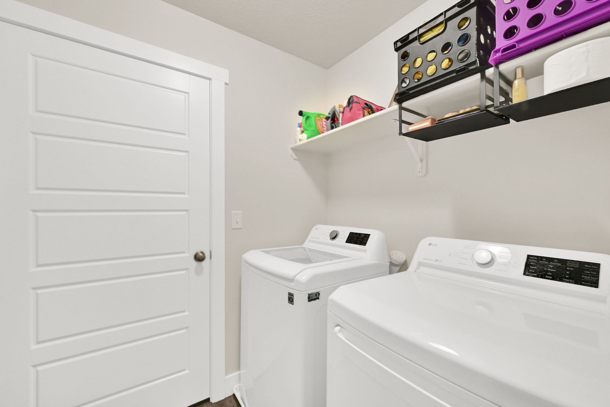 Dedicated laundry area featuring a white paneled door, built-in shelving