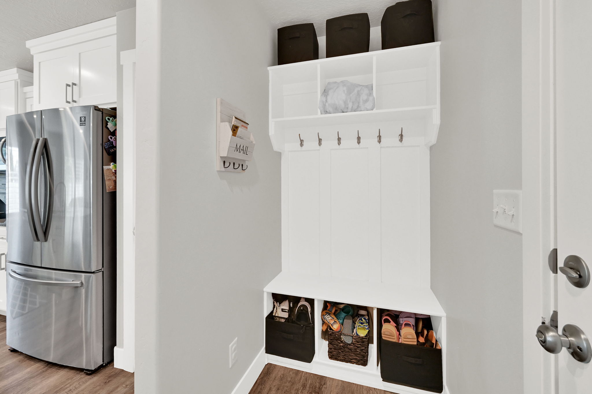 Built-in hall tree with upper shelving, coat hooks, and lower cubbies, complemented by LVP flooring