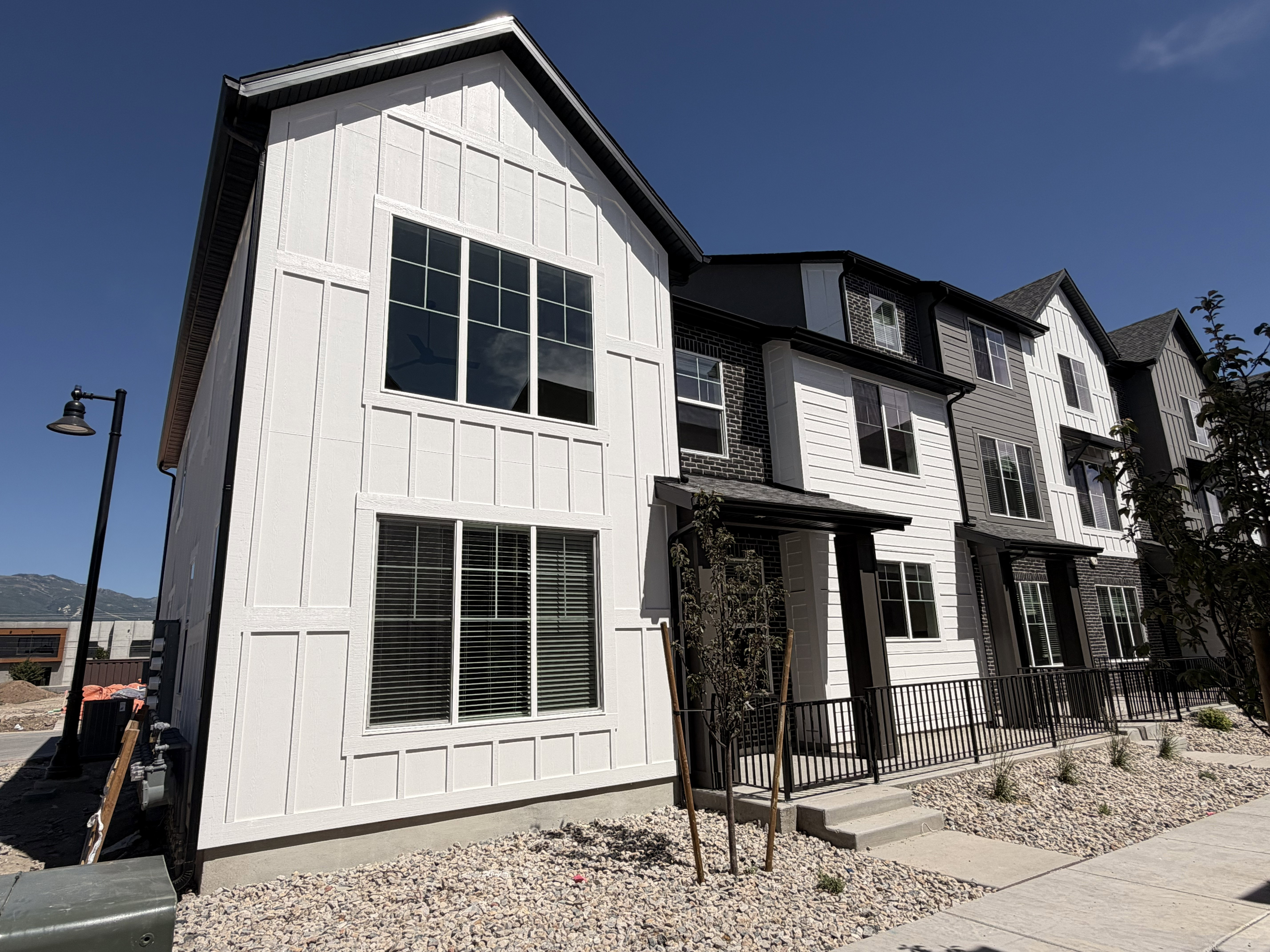 Modern townhome featuring a board and batten facade and an expansive window array