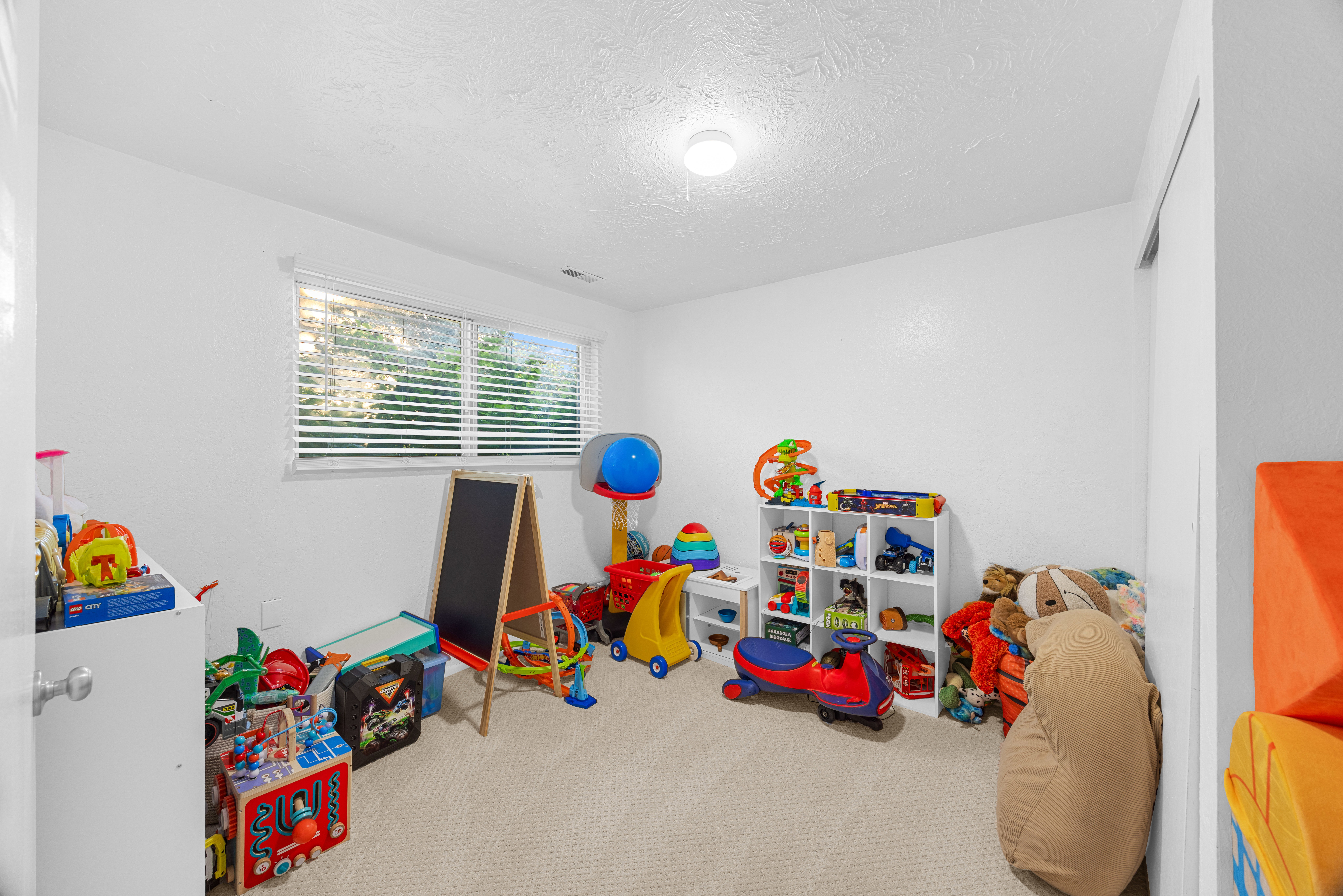 Carpeted room with a single window featuring horizontal blinds