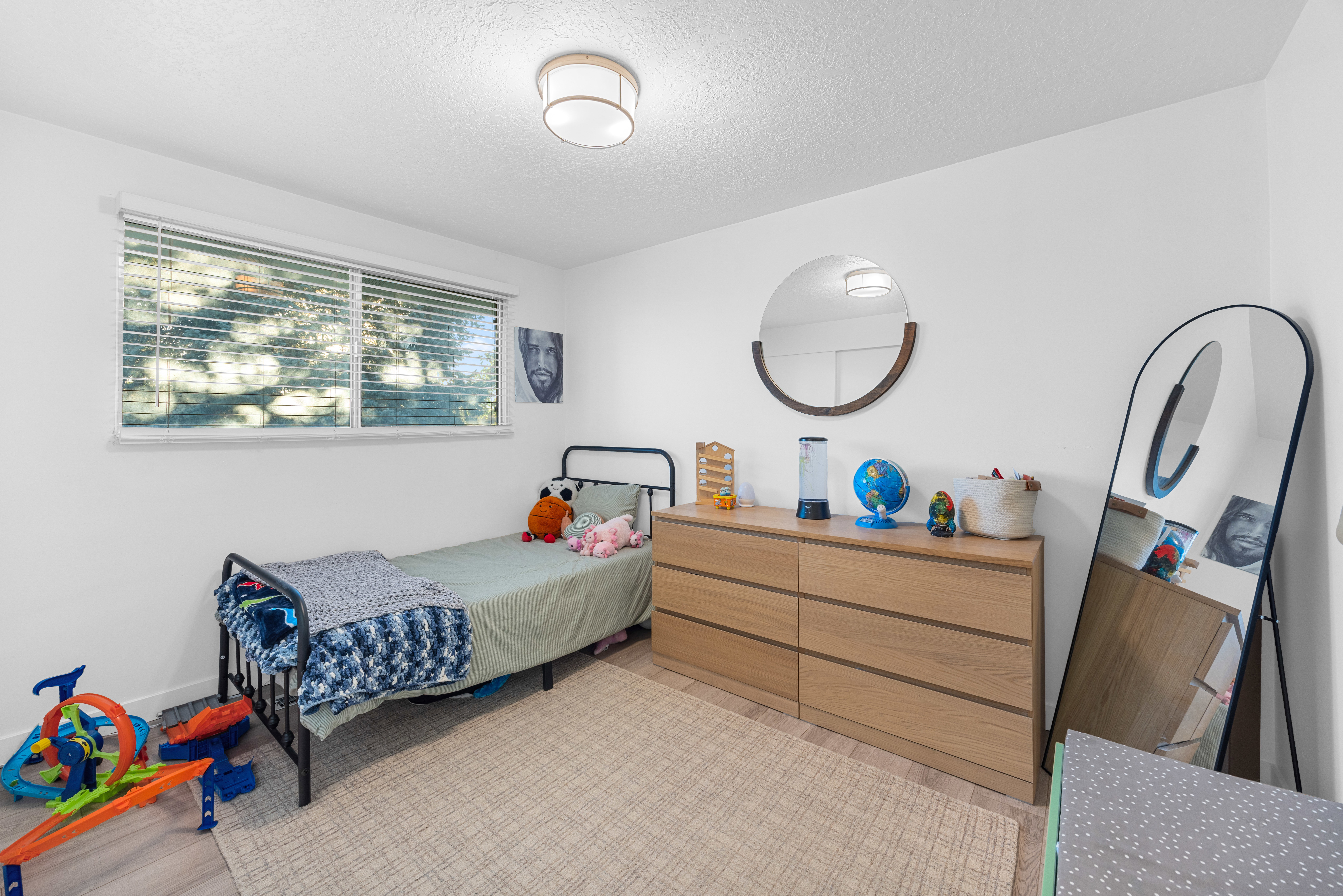 Bright bedroom with a window featuring horizontal blinds