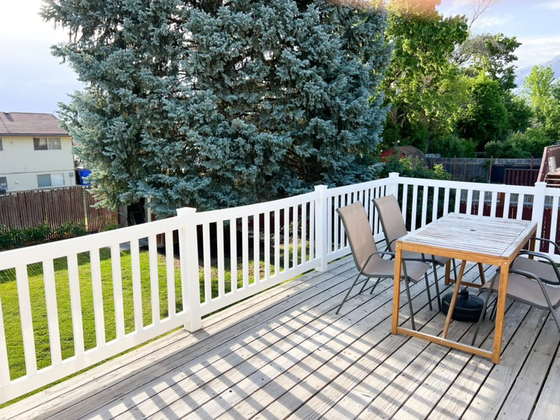 Spacious outdoor deck with wood-finish flooring and white perimeter railings