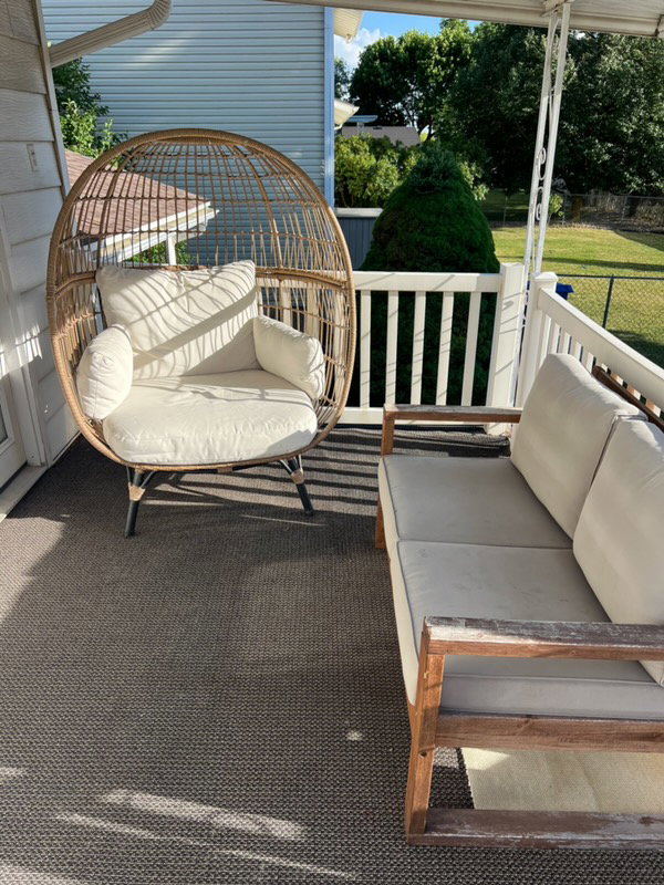 Covered porch featuring a textured dark gray outdoor rug