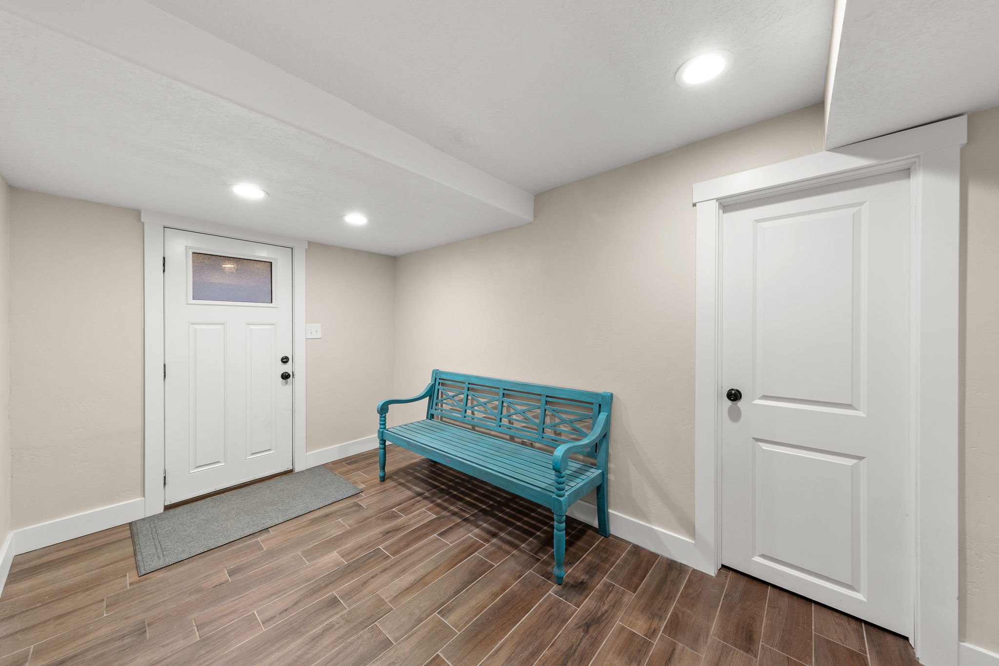 Entryway featuring wood-finish tile flooring, recessed lighting, and a white paneled door with a frosted transom window!