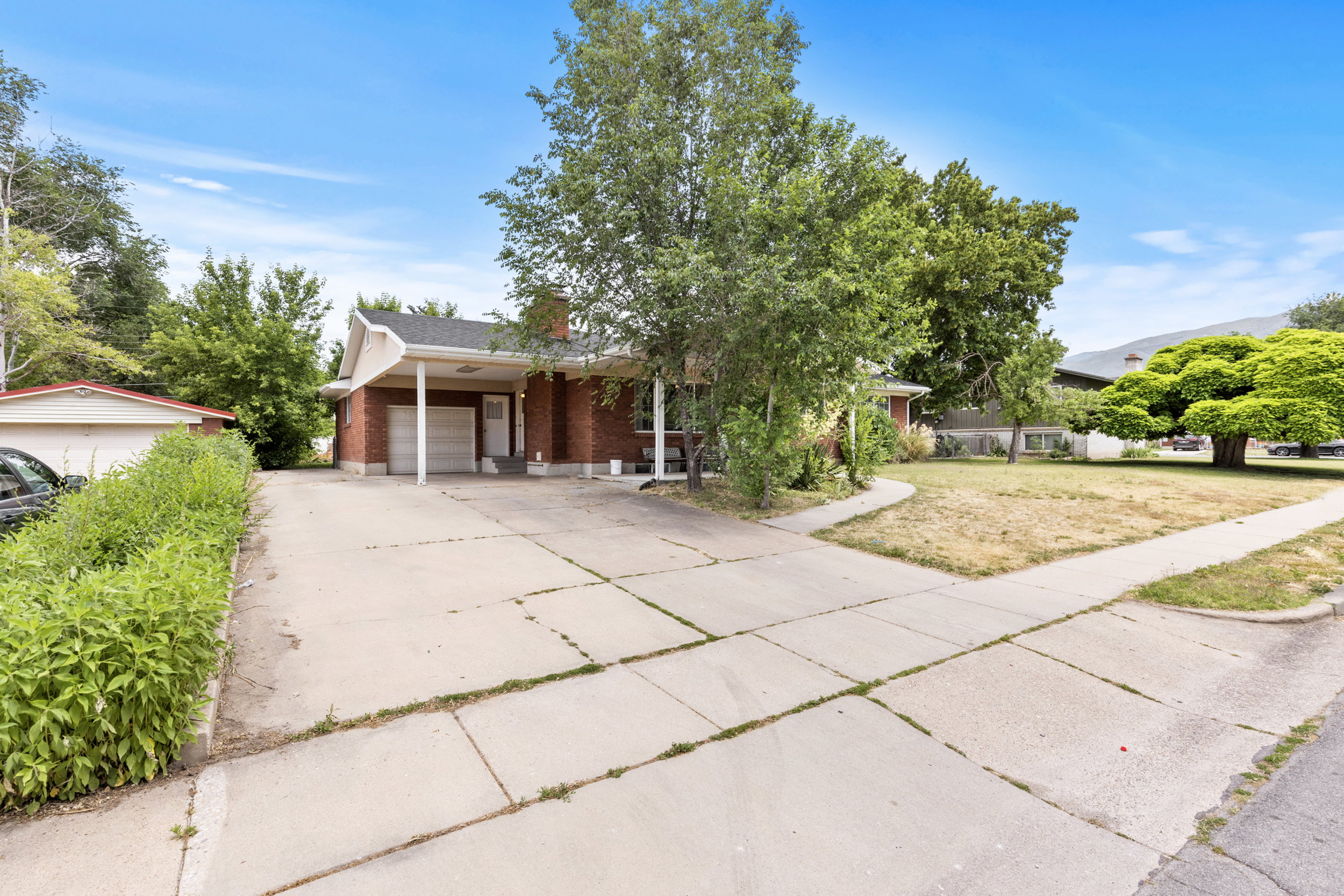Brick exterior residence with a covered carport and attached single-car garage