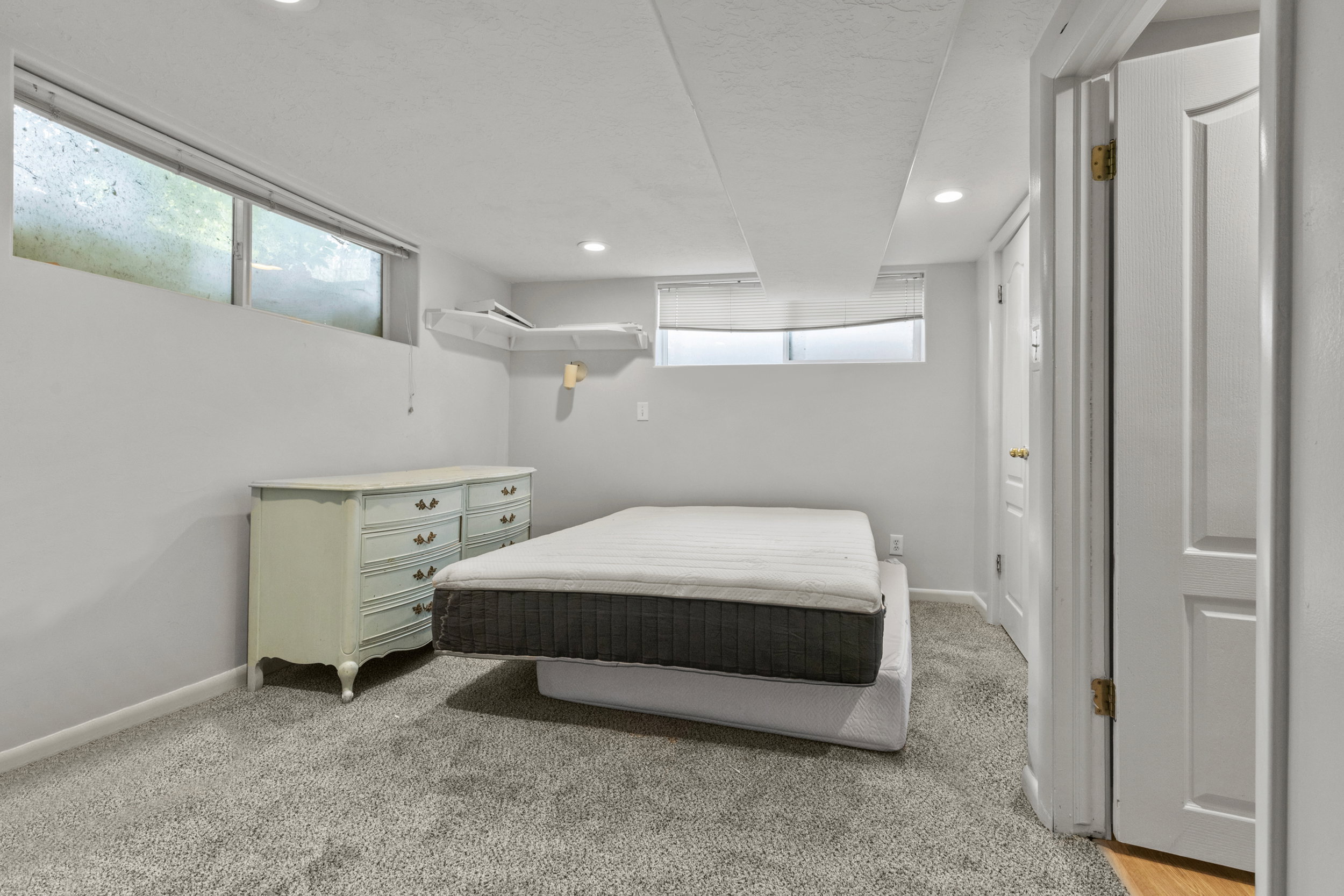 Carpeted room featuring recessed lighting, a horizontal window, and a built-in wall shelf