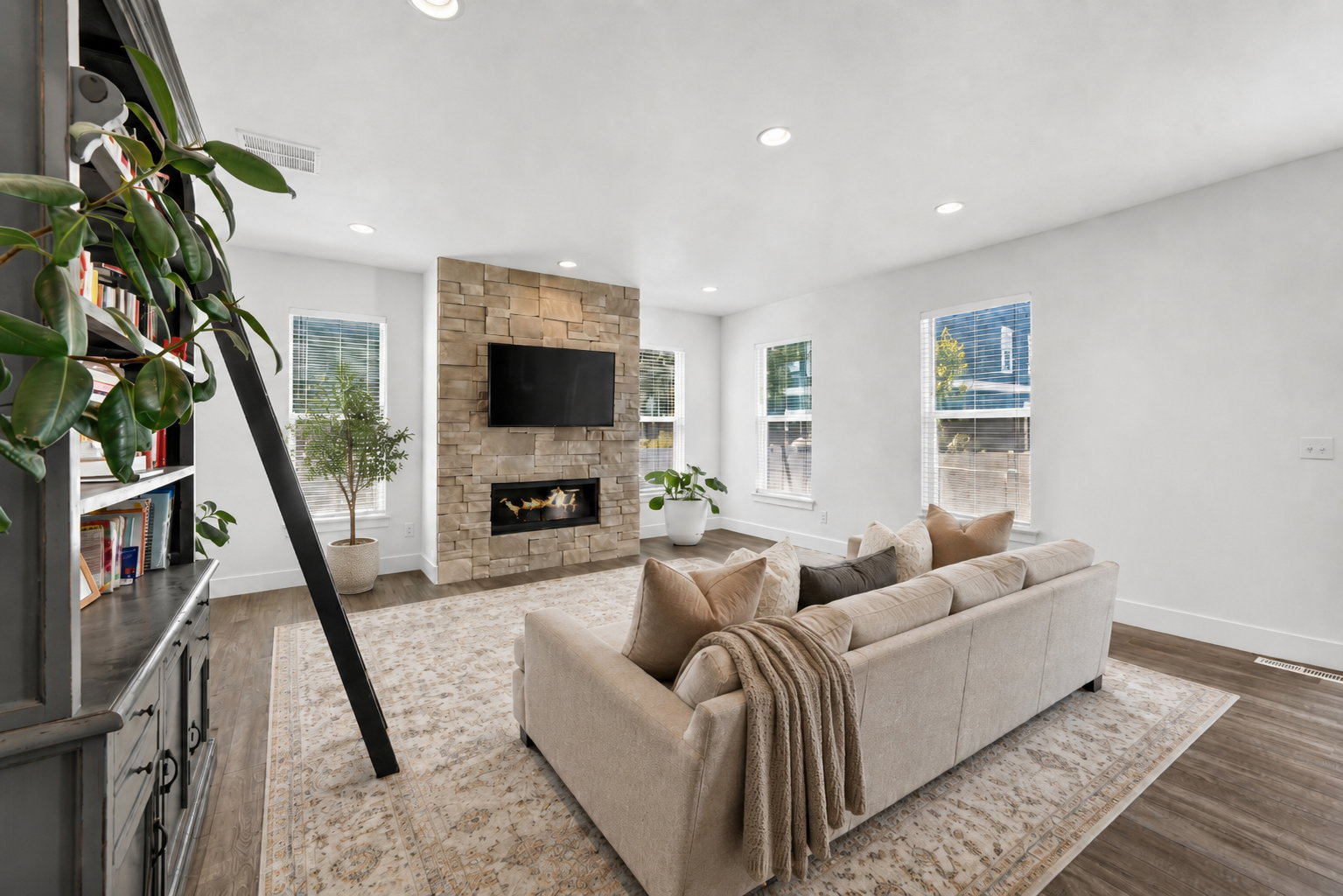 Living area featuring a floor-to-ceiling stone-clad fireplace with an integrated linear firebox