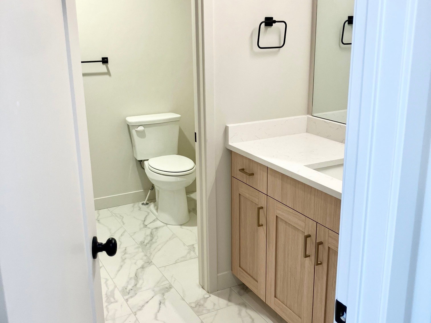 Bathroom featuring a wood-finish vanity with a light-colored countertop and undermount sink