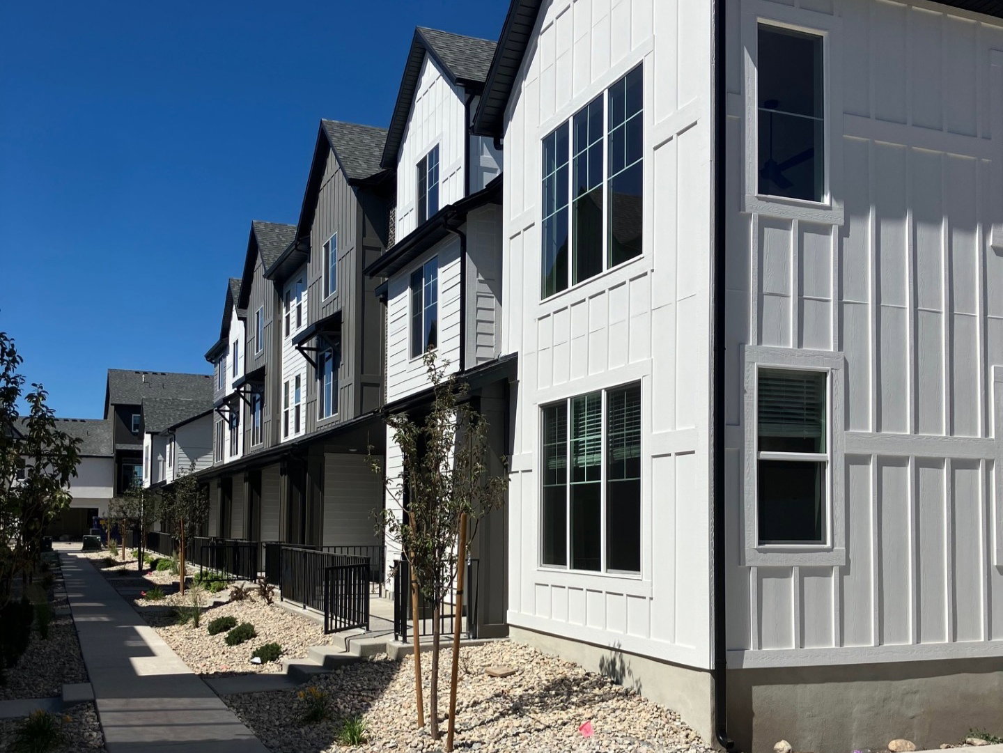 Modern row of homes featuring board and batten siding with dark trim accents