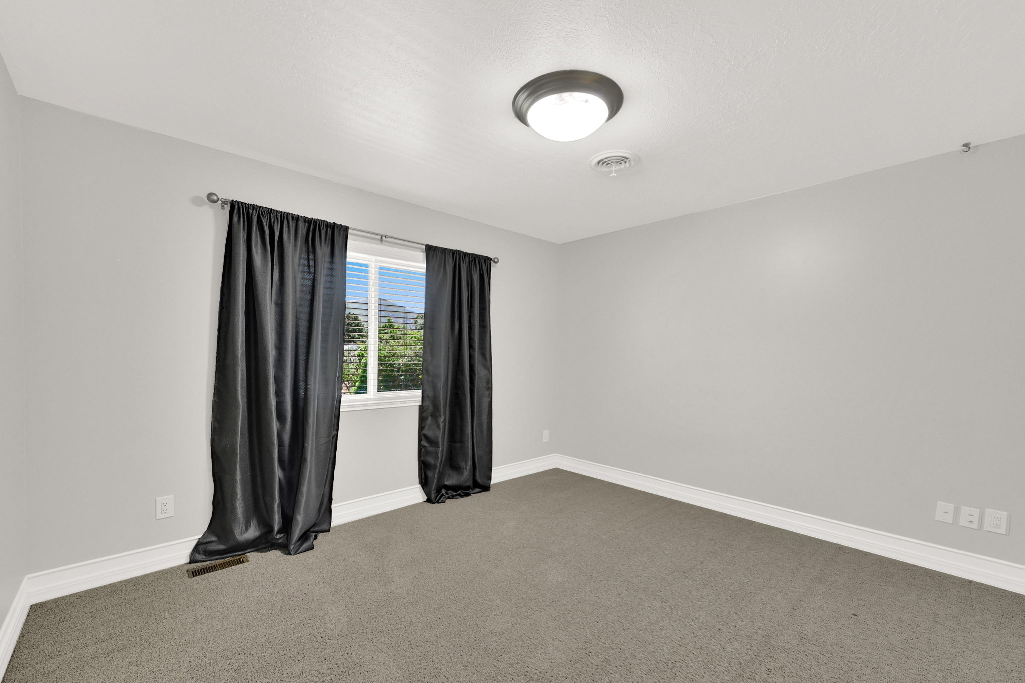 Bedroom #3 carpeted room with light gray walls, white baseboards, and a single window