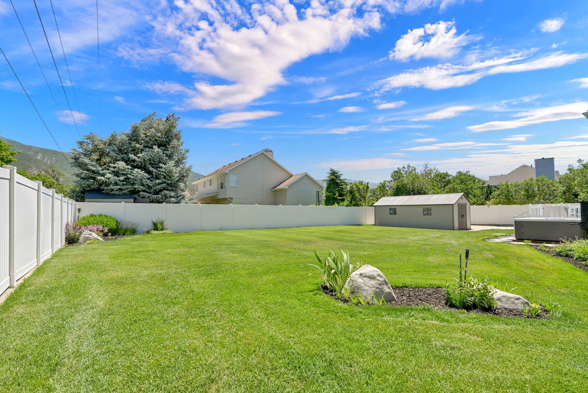 Expansive green lawn framed by a white privacy fence