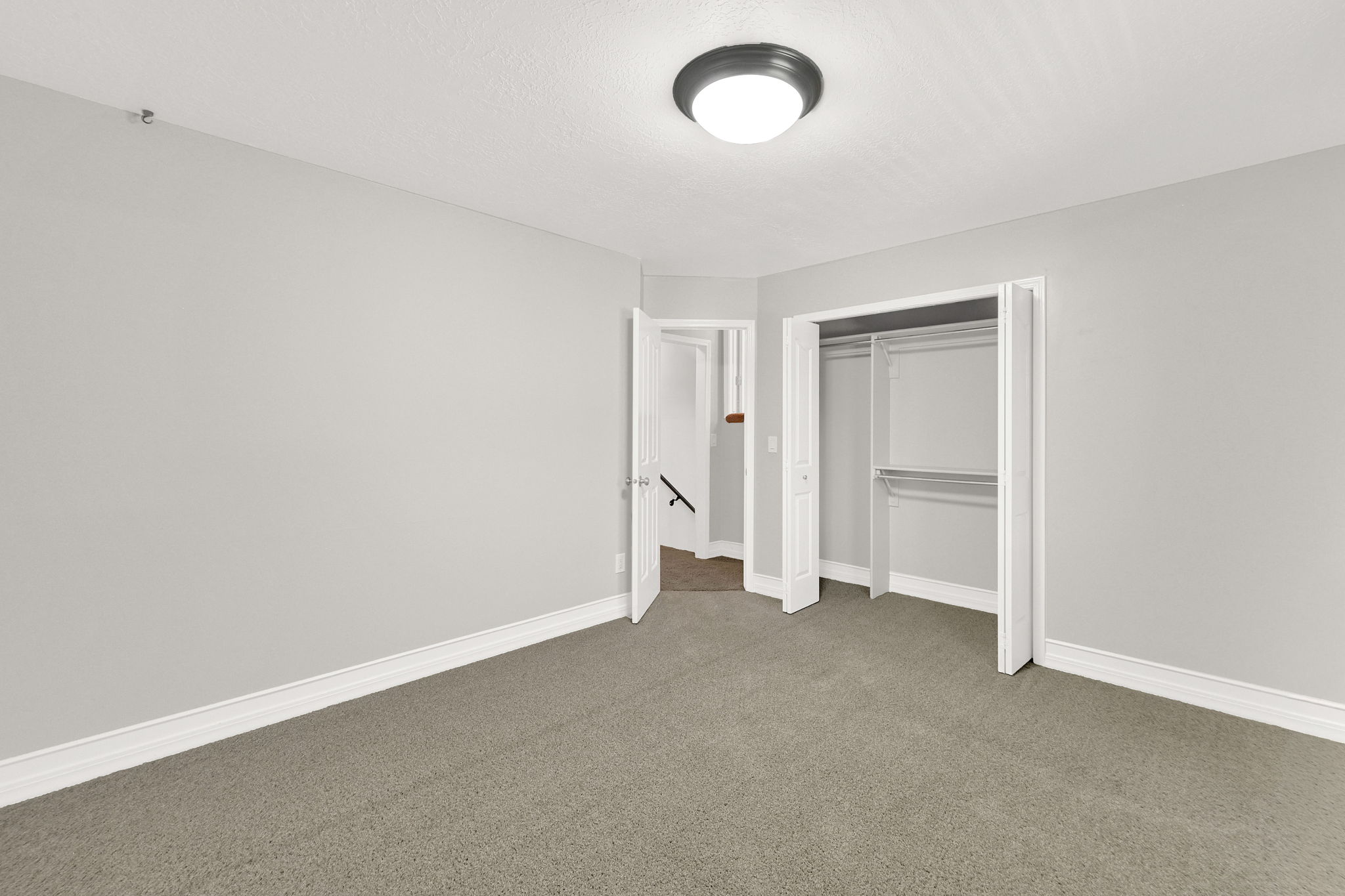 Bedroom #3 with neutral gray-toned room featuring a flush mount ceiling light fixture