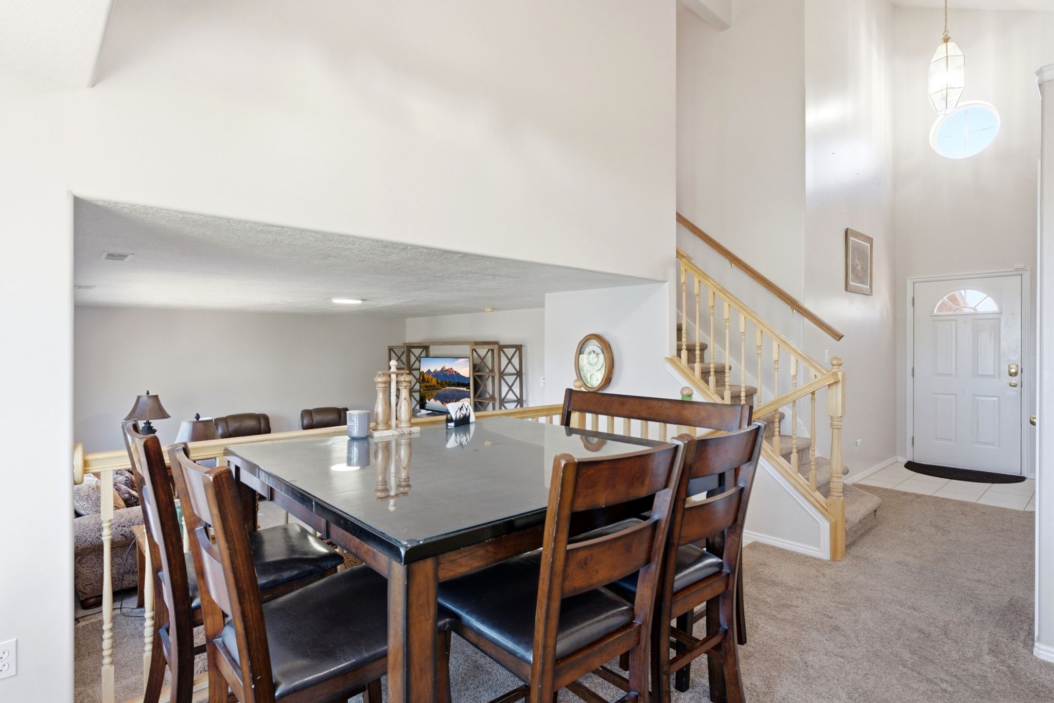 Foyer with a dual-height ceiling, arched window entryway, and carpeted staircase with wood banister