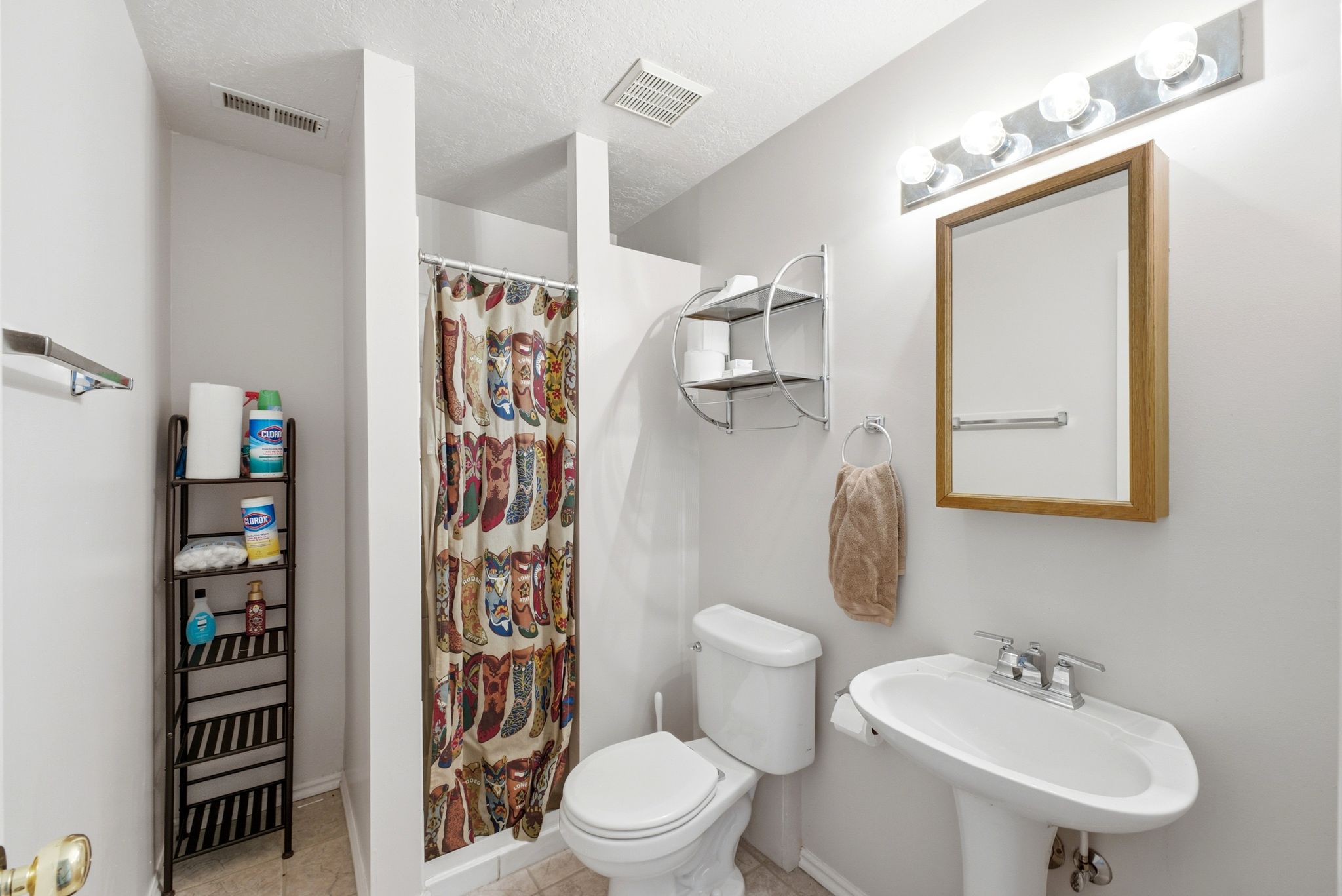 Pedestal sink with chrome faucet, framed mirror, and chrome vanity lighting