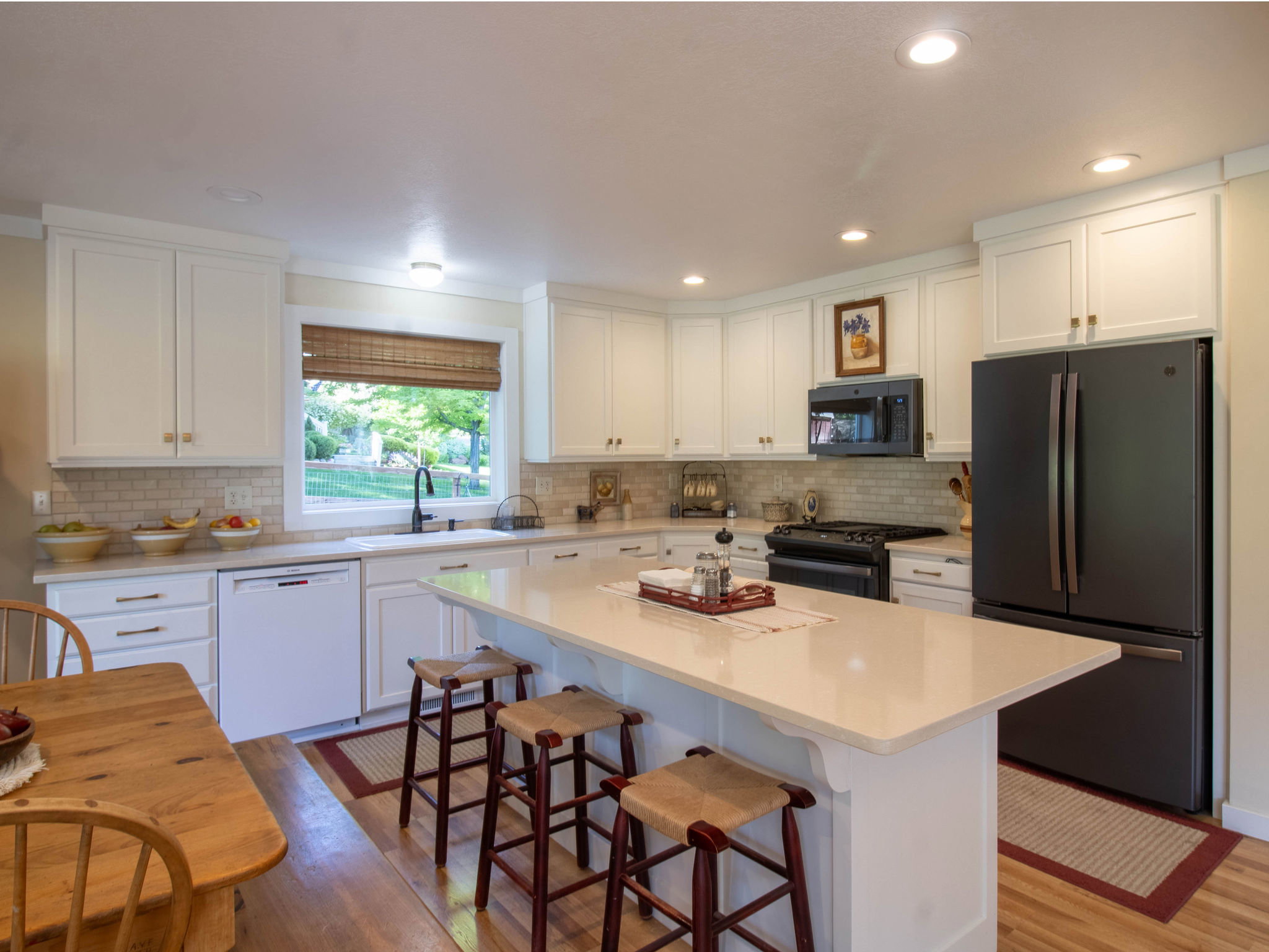 Kitchen featuring white cabinetry, light-toned countertops, a subway tile backsplash, recessed lighting, and wood-finish flooring