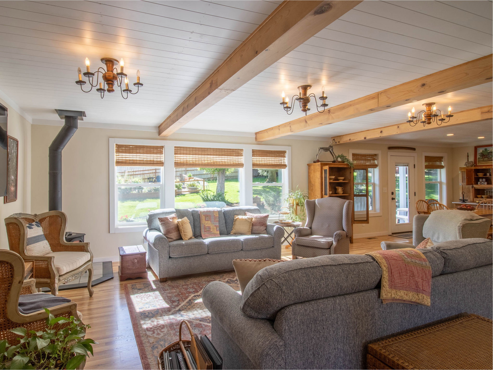 Living room featuring a wood-finish ceiling with exposed wood beams and chandelier lighting