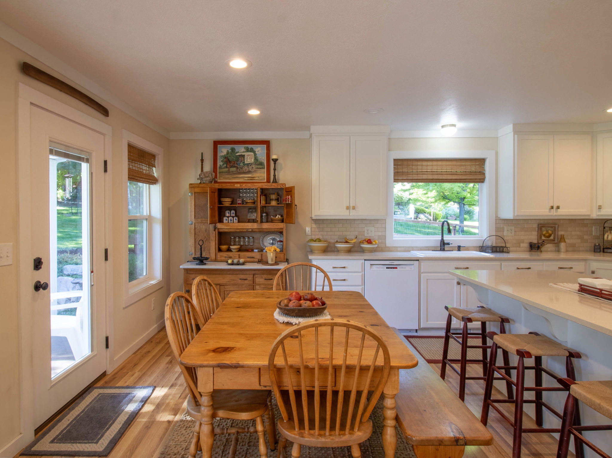 Kitchen featuring white cabinetry, light countertops, subway tile backsplash, wood-finish flooring, and recessed lighting