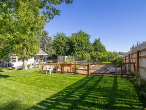 Expansive backyard featuring a manicured lawn, a fenced garden area, and a privacy fence