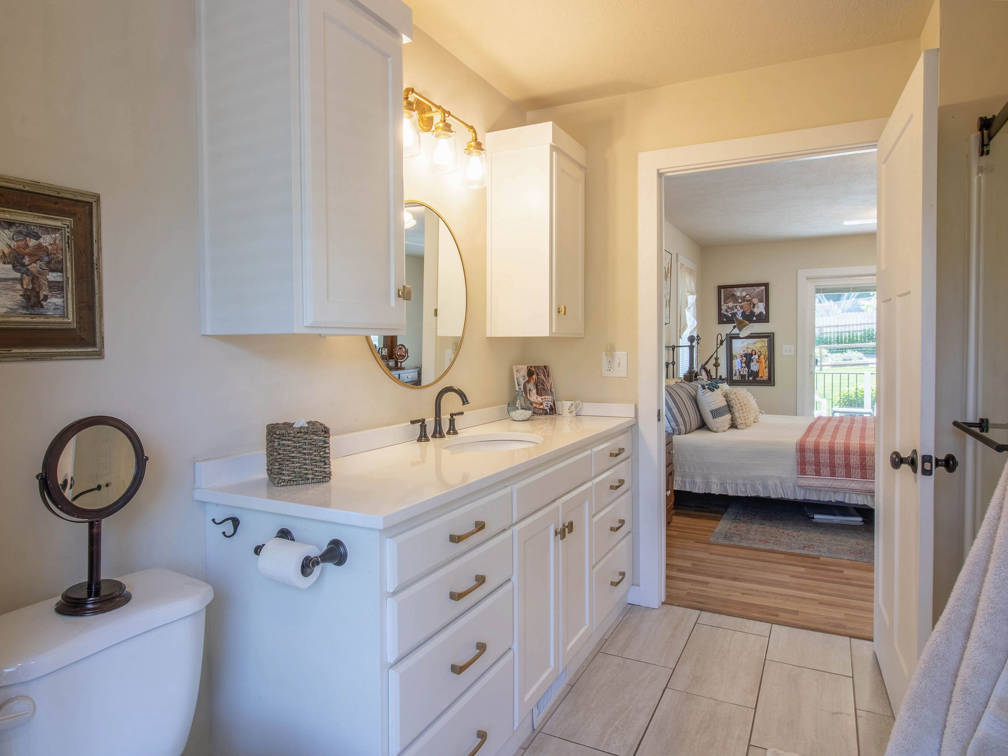 Contemporary bathroom vanity with white cabinetry, gold-tone hardware, and a white countertop