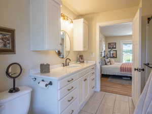 Contemporary bathroom vanity with white cabinetry, gold-tone hardware, and a white countertop