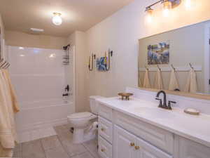 Bathroom featuring a white vanity with gold-toned hardware, an integrated sink, and a dark-toned faucet