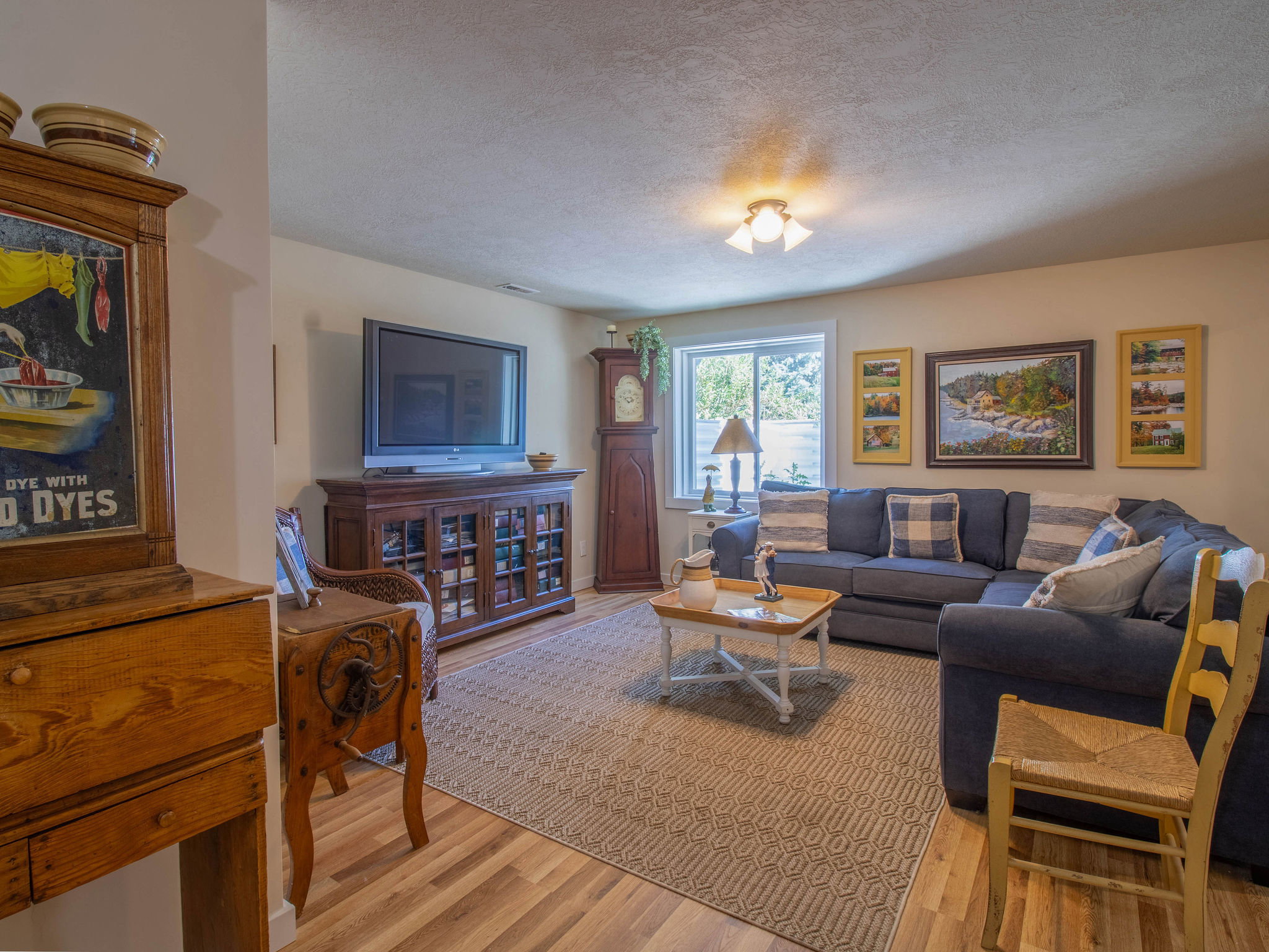 Bright living area featuring wood-finish flooring, a recessed window, and light-colored walls