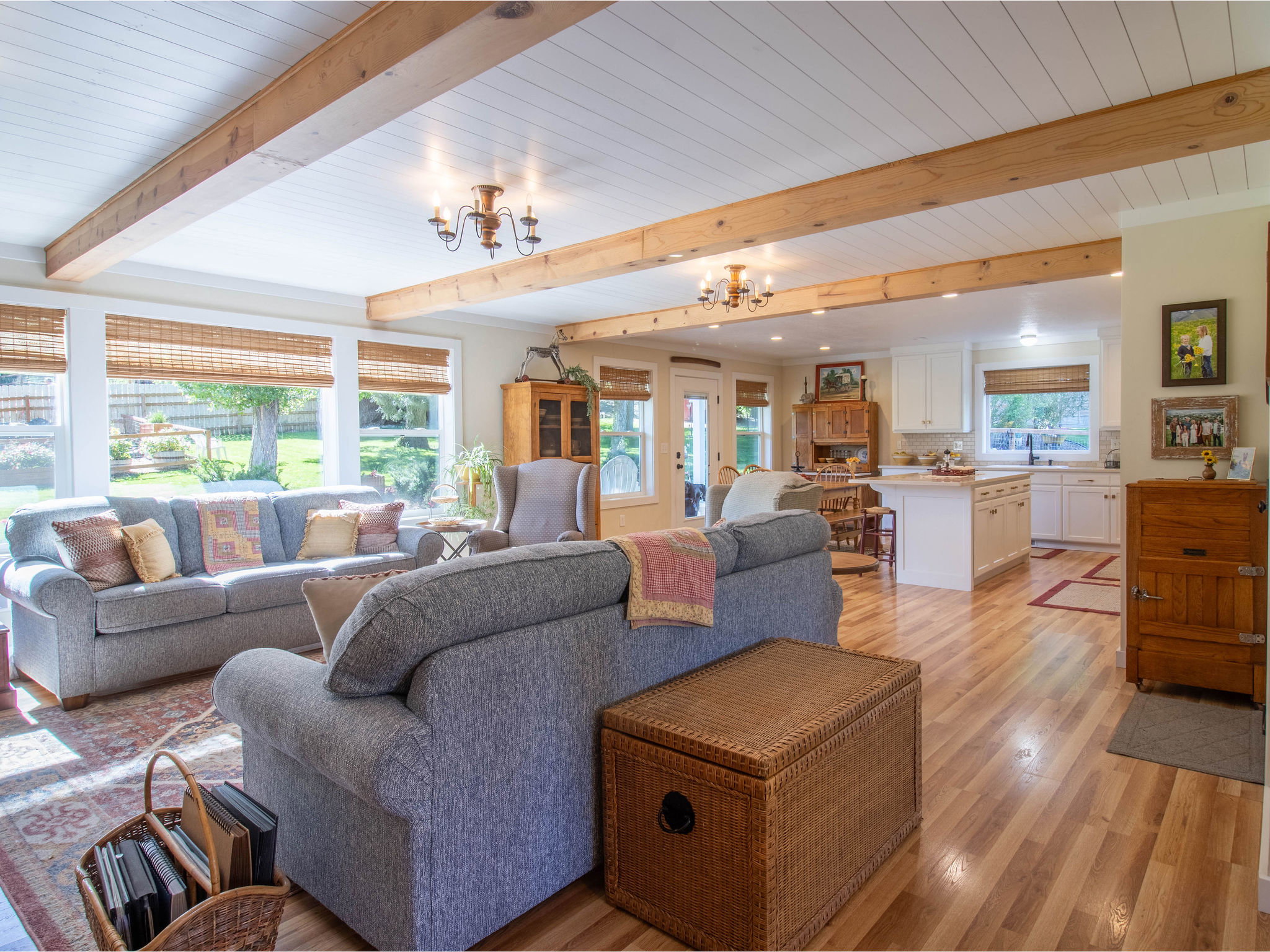 Open-concept living space featuring wood-finish flooring, exposed ceiling beams, and white shiplap ceiling