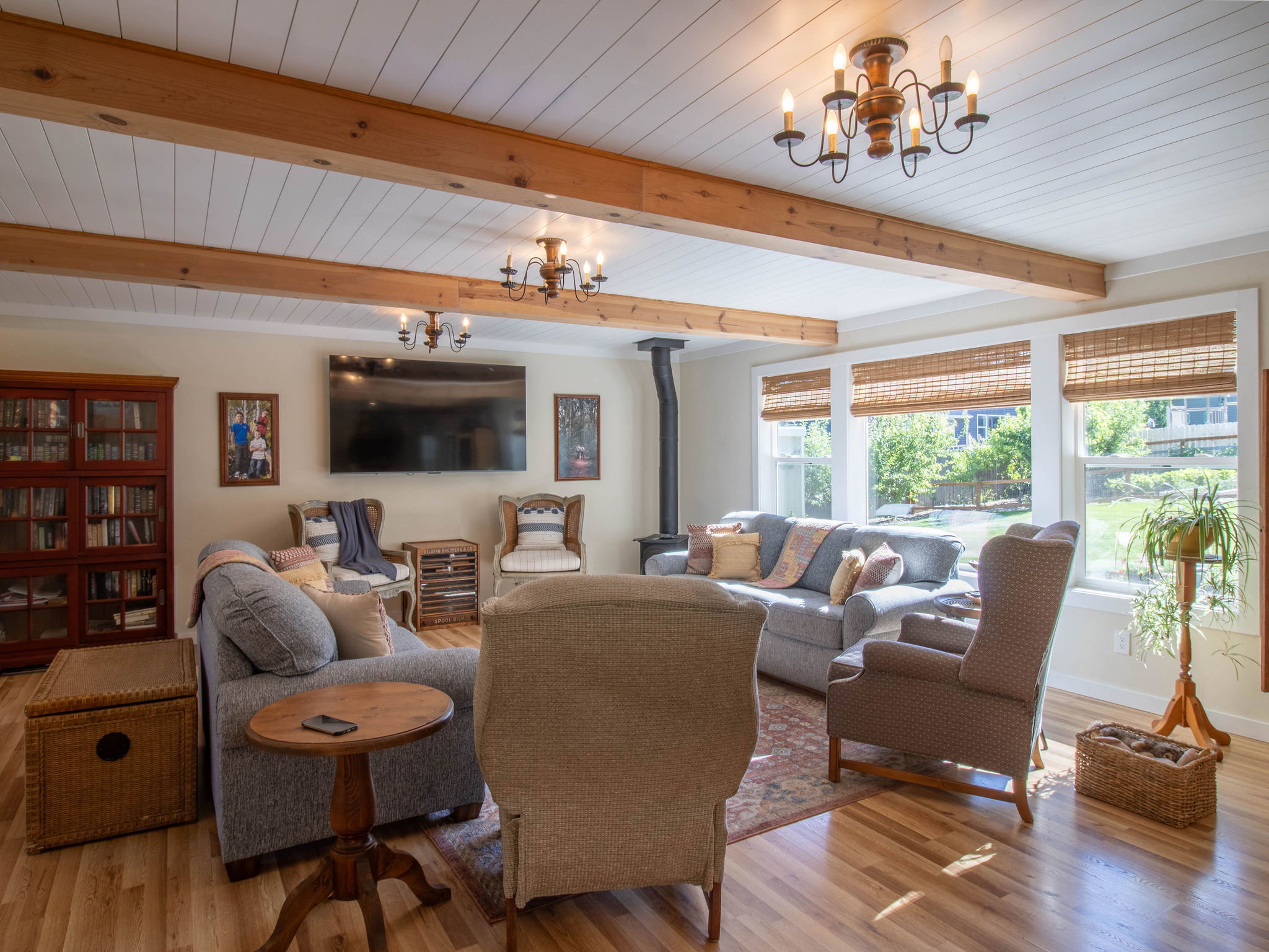 Spacious room featuring wood-finish flooring, exposed wood beams, and a shiplap ceiling