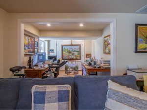 Recessed lighting illuminates this versatile interior space with warm beige walls and light wood-finish flooring