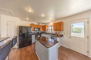 Kitchen featuring wood-finish flooring, recessed lighting, and a center island with a dark countertop
