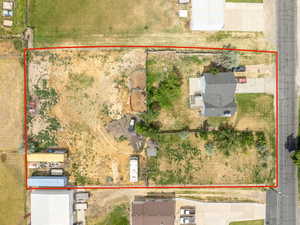 Expansive land parcel featuring a detached residence with a dark-pitched roof and light-colored siding