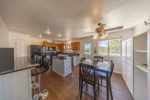 Open-concept kitchen and dining area featuring wood-finish flooring, recessed lighting, and a ceiling fan