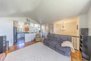 Open-concept living area featuring vaulted ceilings and wood-finish flooring