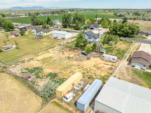 Expansive land parcel featuring existing residential structures, an outbuilding, and mature trees
