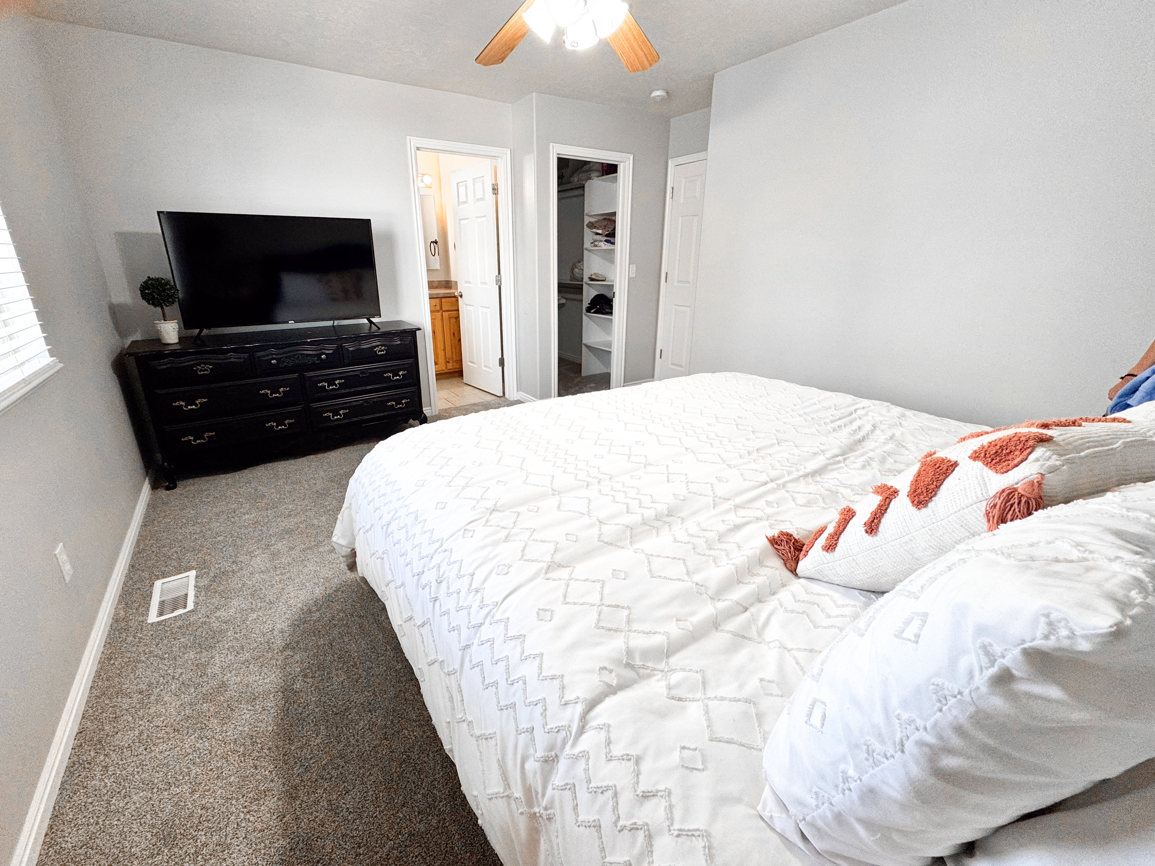 Carpeted room with a ceiling fan light fixture, light gray walls, and white trim