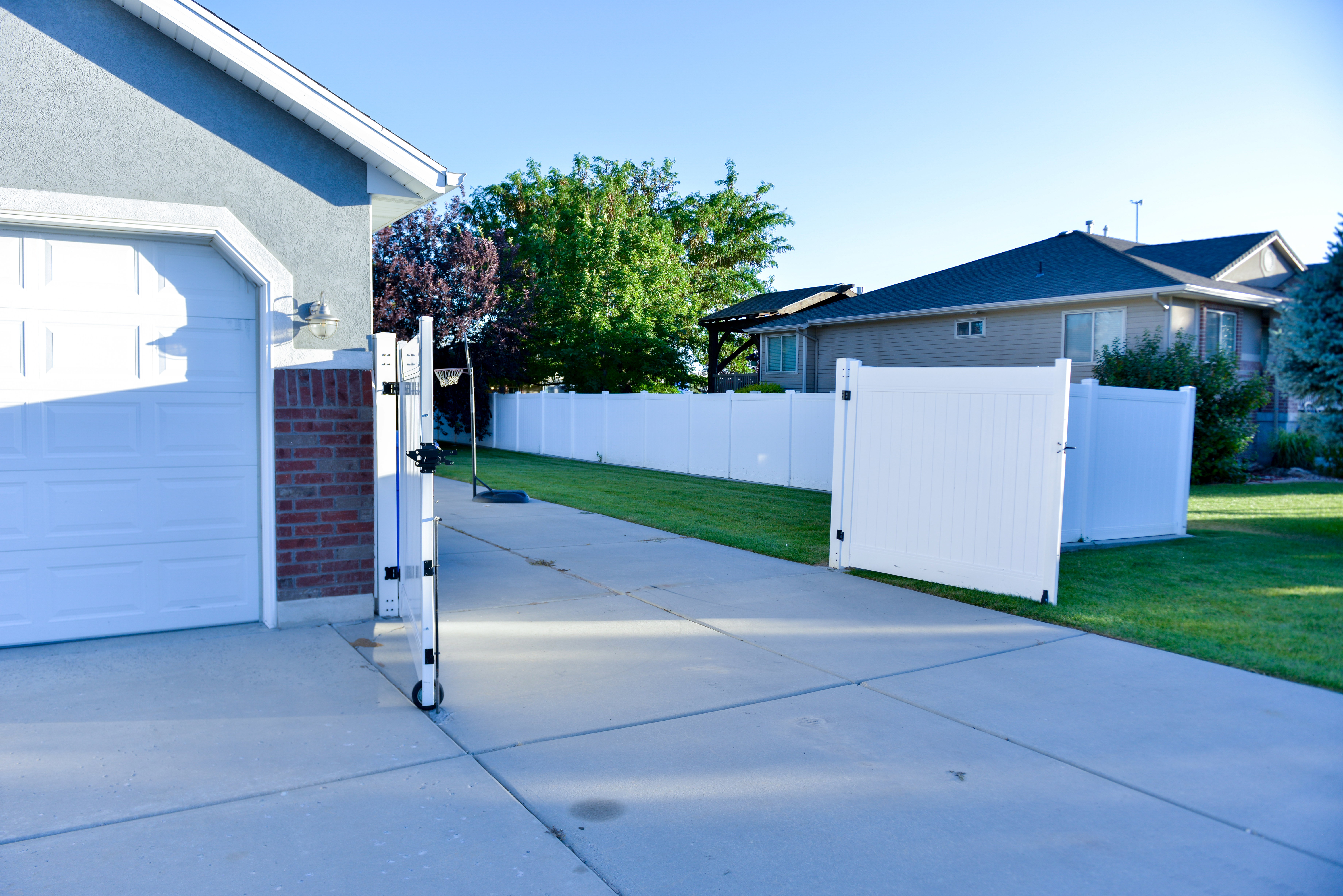 Concrete driveway with a vinyl privacy fence