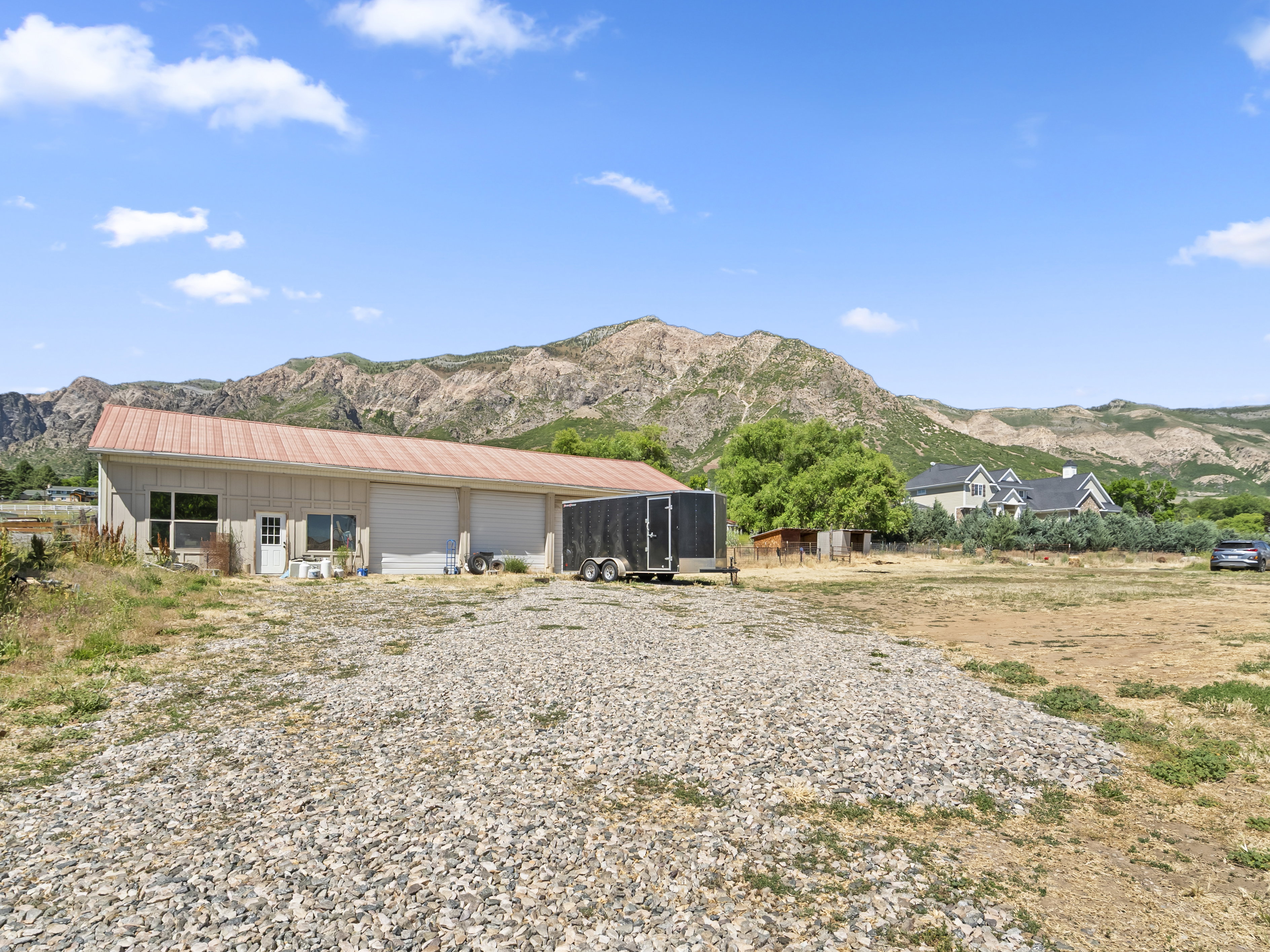 Spacious outbuilding featuring a metal roof, multiple garage doors, and a pedestrian entry