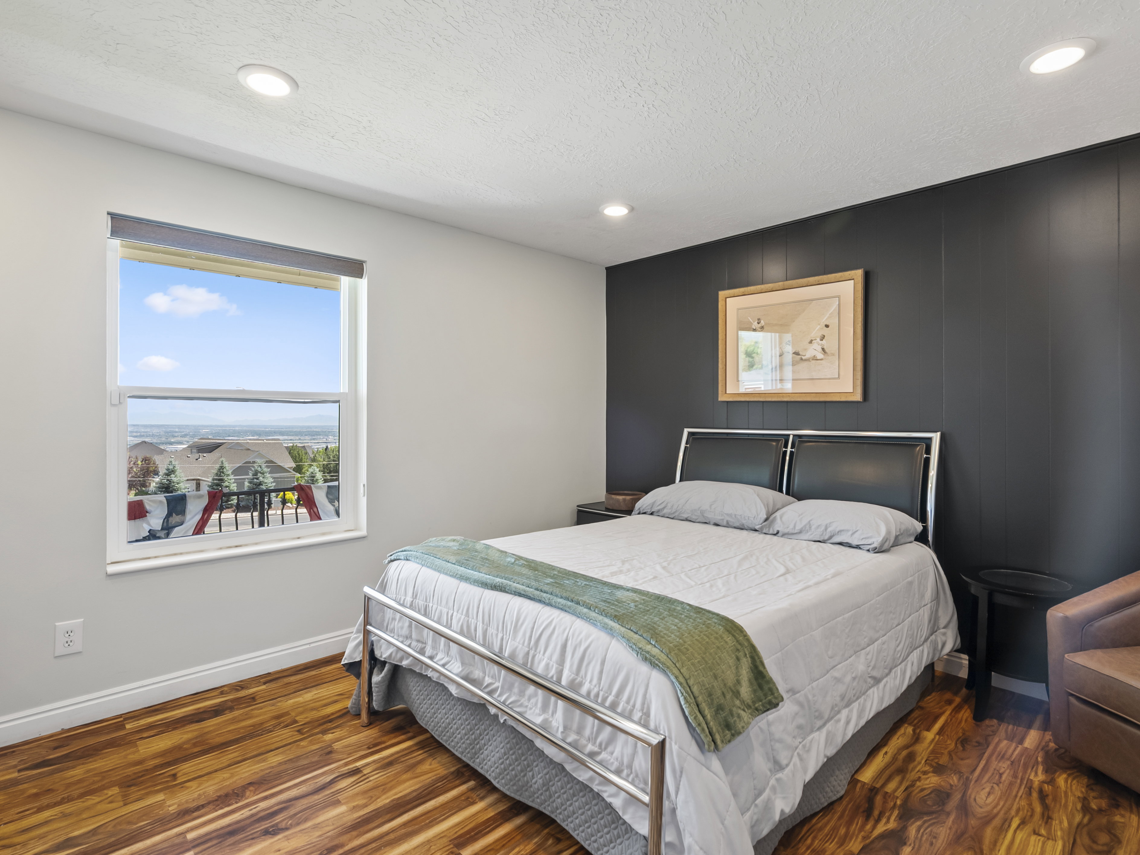 Bedroom featuring wood-finish flooring, recessed lighting, and a window with a distant landscape
