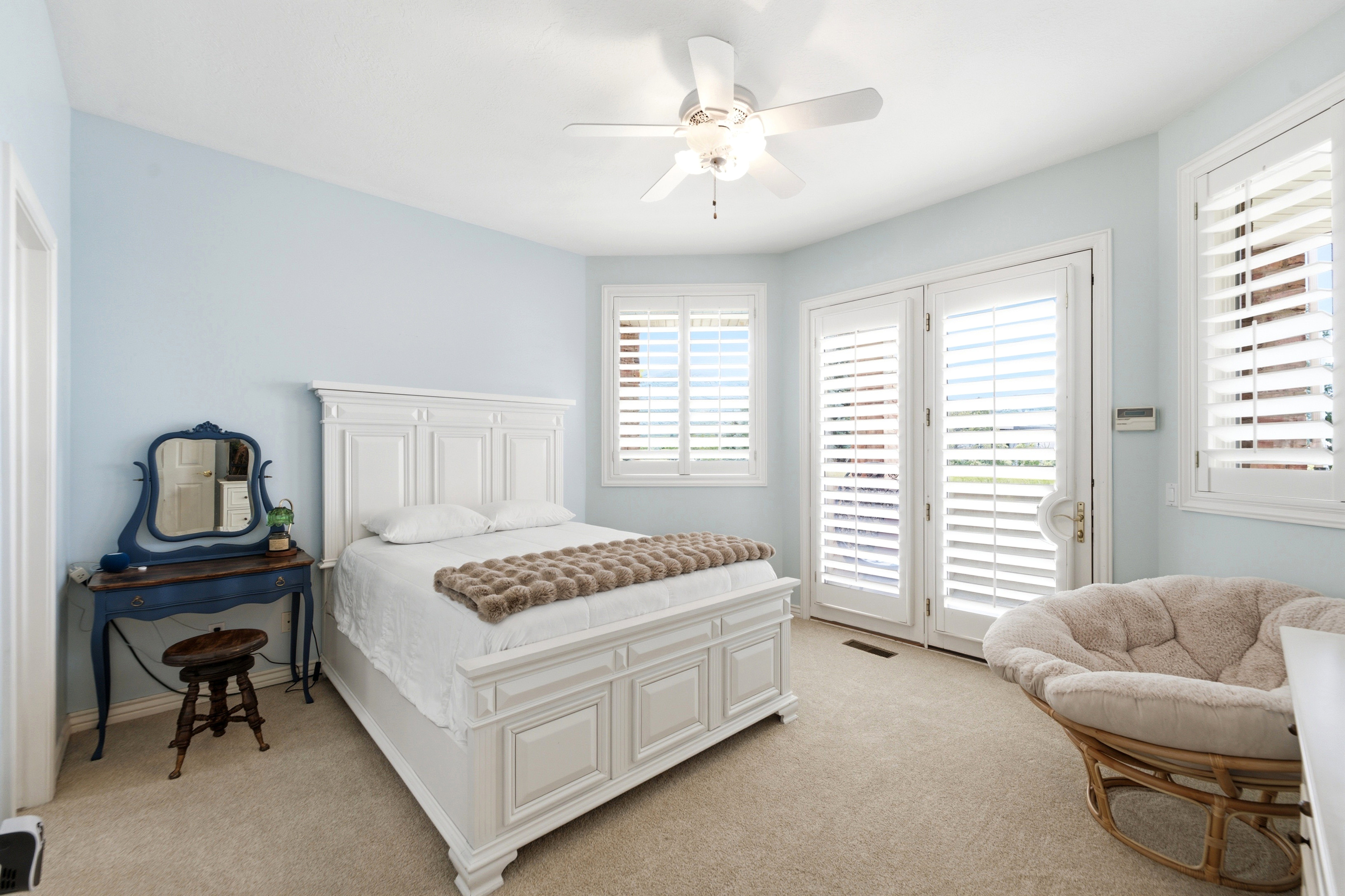 One of three BedroomsBright room with light blue walls and neutral carpeting