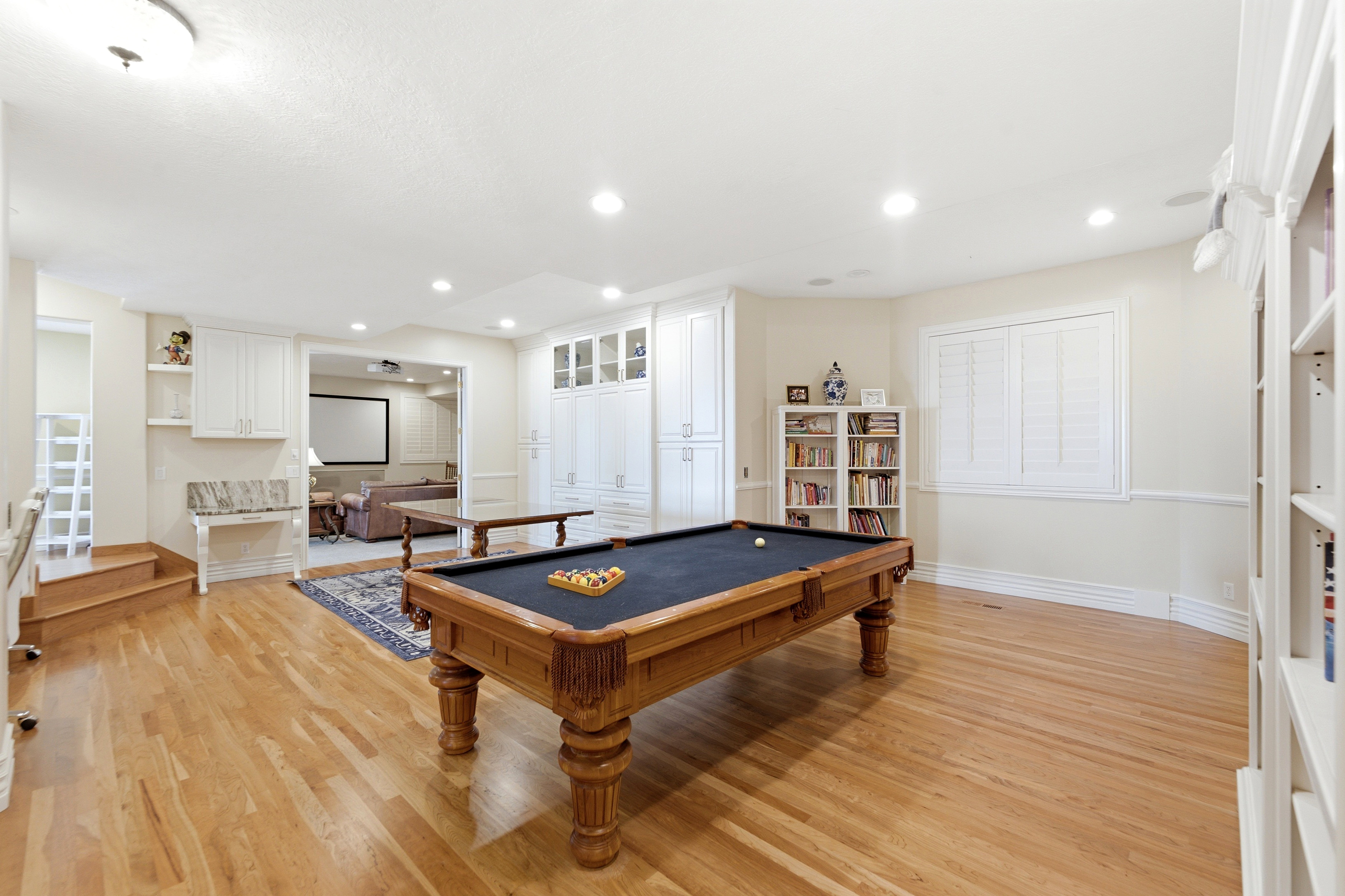 Spacious recreation area featuring wood-finish flooring to match main level, recessed lighting, and built-in cabinets.