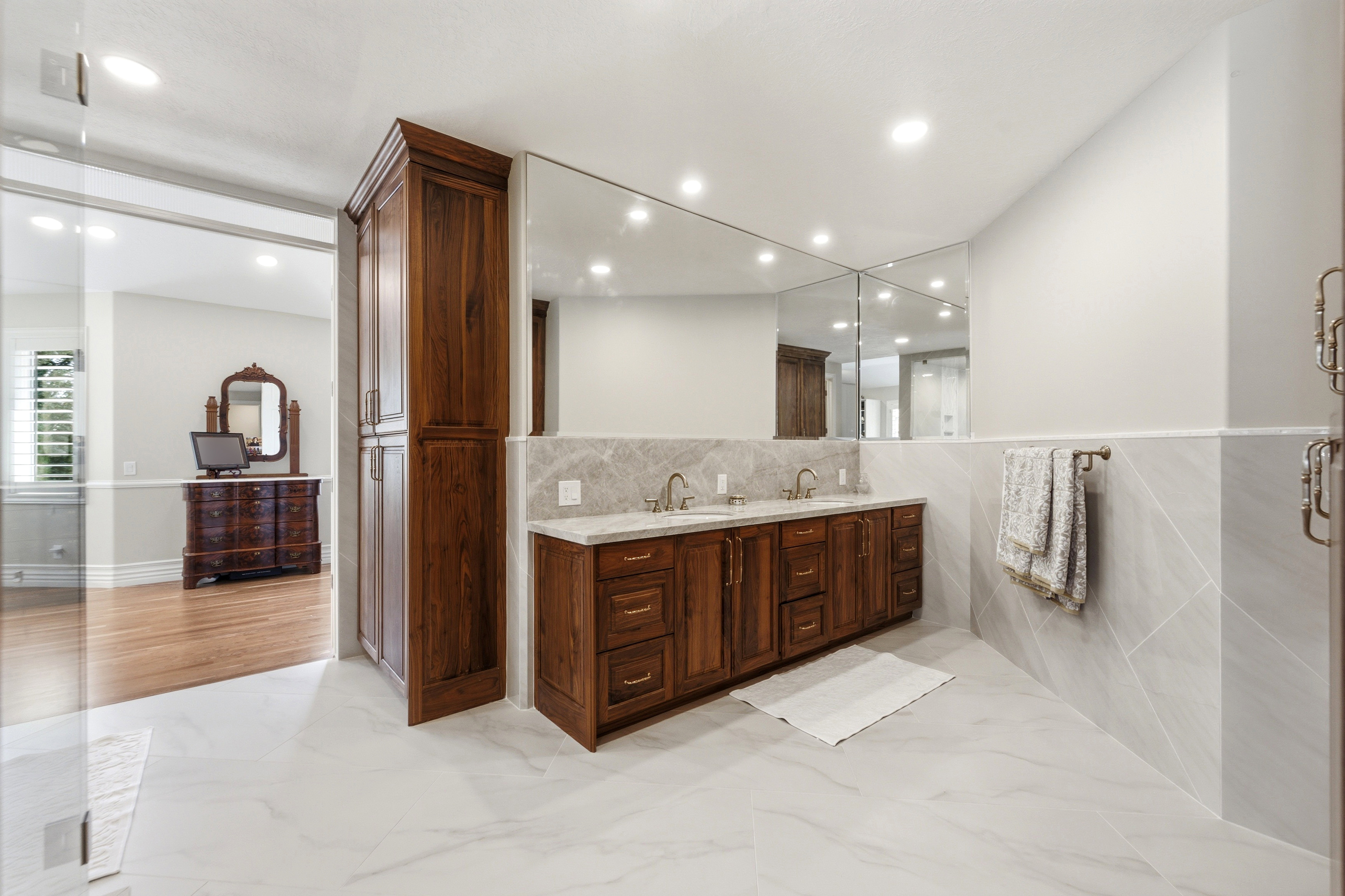Dual vanity with wood-finish cabinetry, integrated sinks, and polished countertops