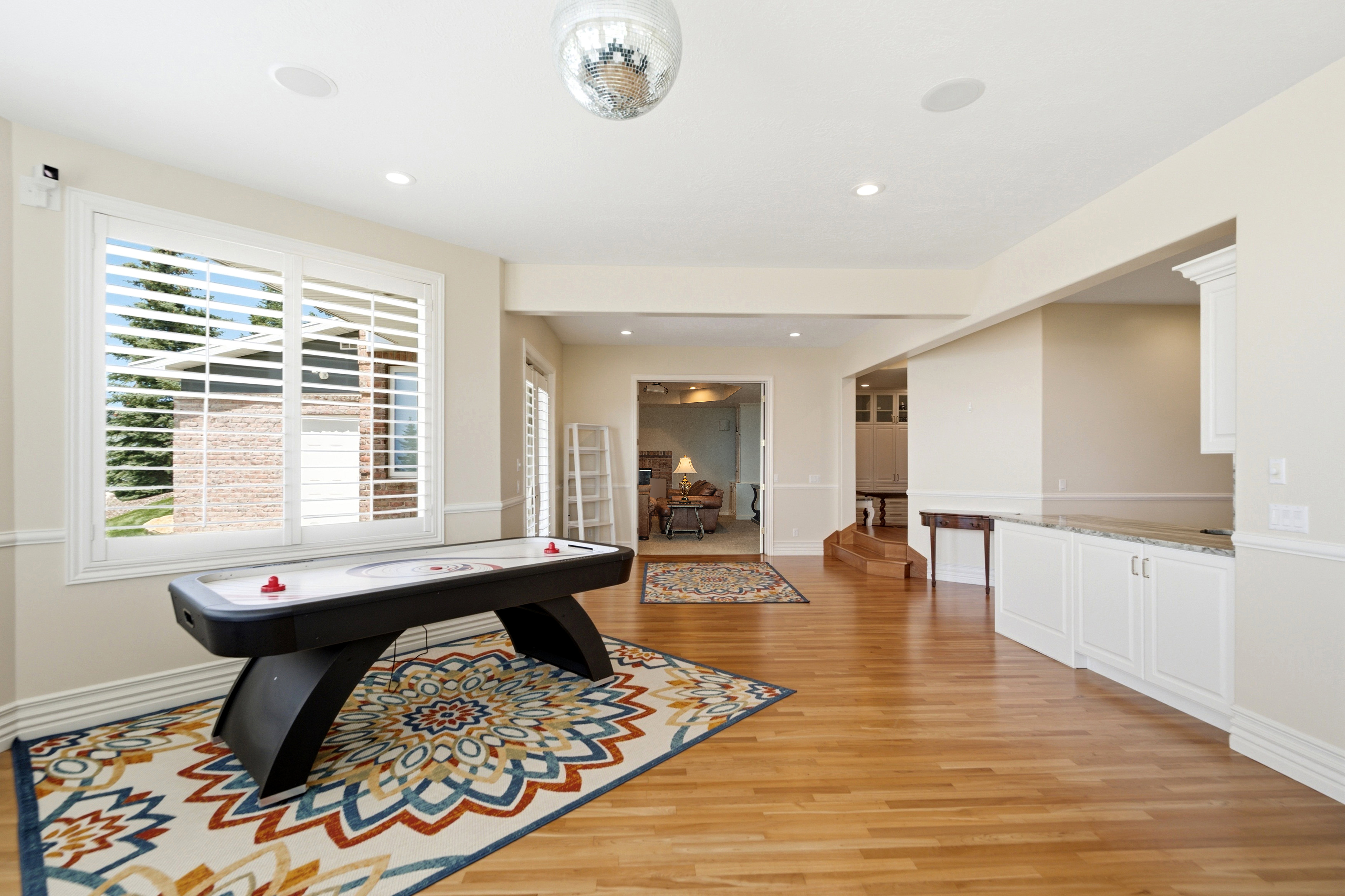 Spacious room featuring wood-finish flooring, recessed lighting, and a built-in cabinetry with a stone countertop