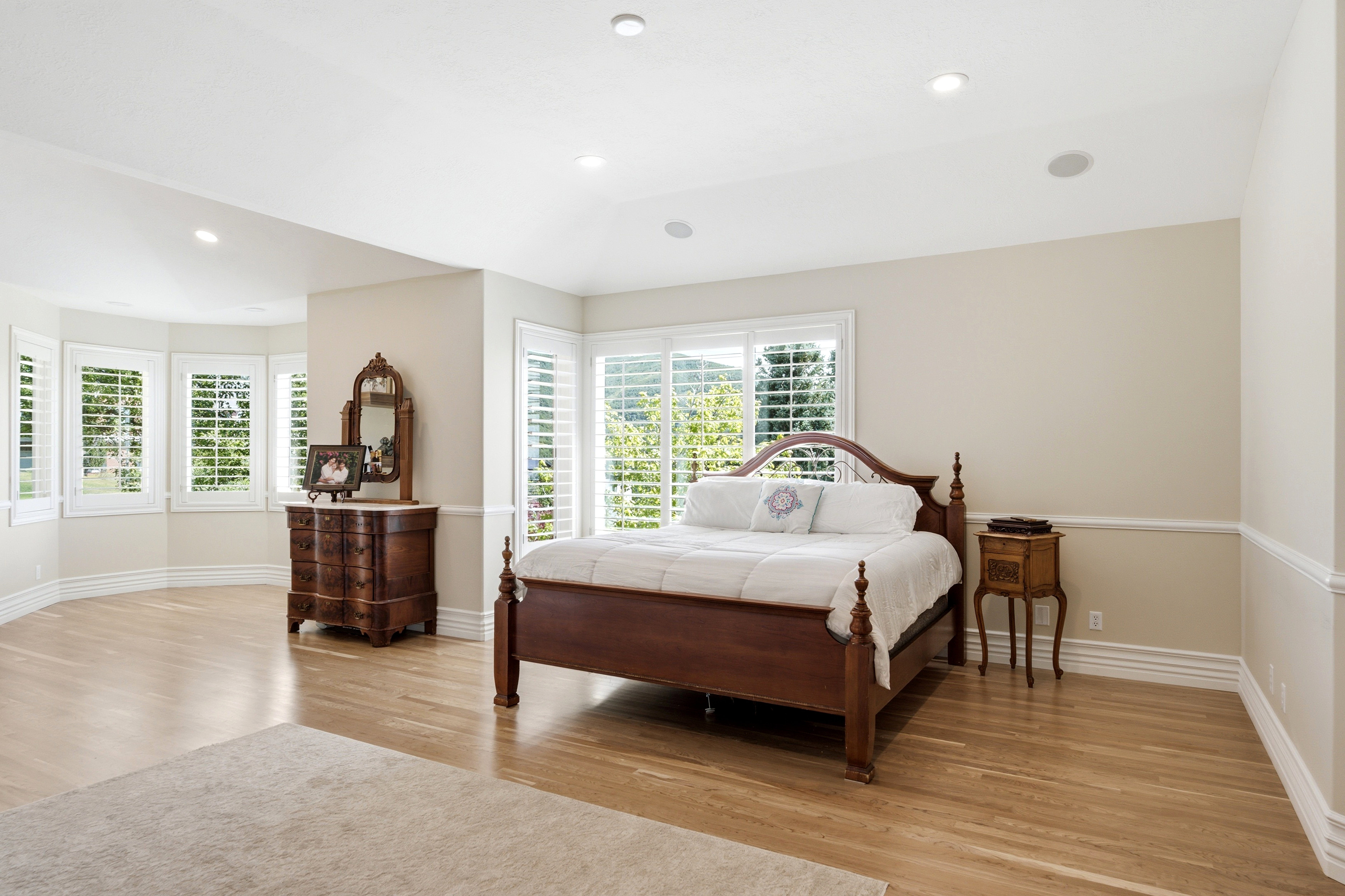 Spacious room featuring light wood-finish flooring and extensive natural light from multiple windows